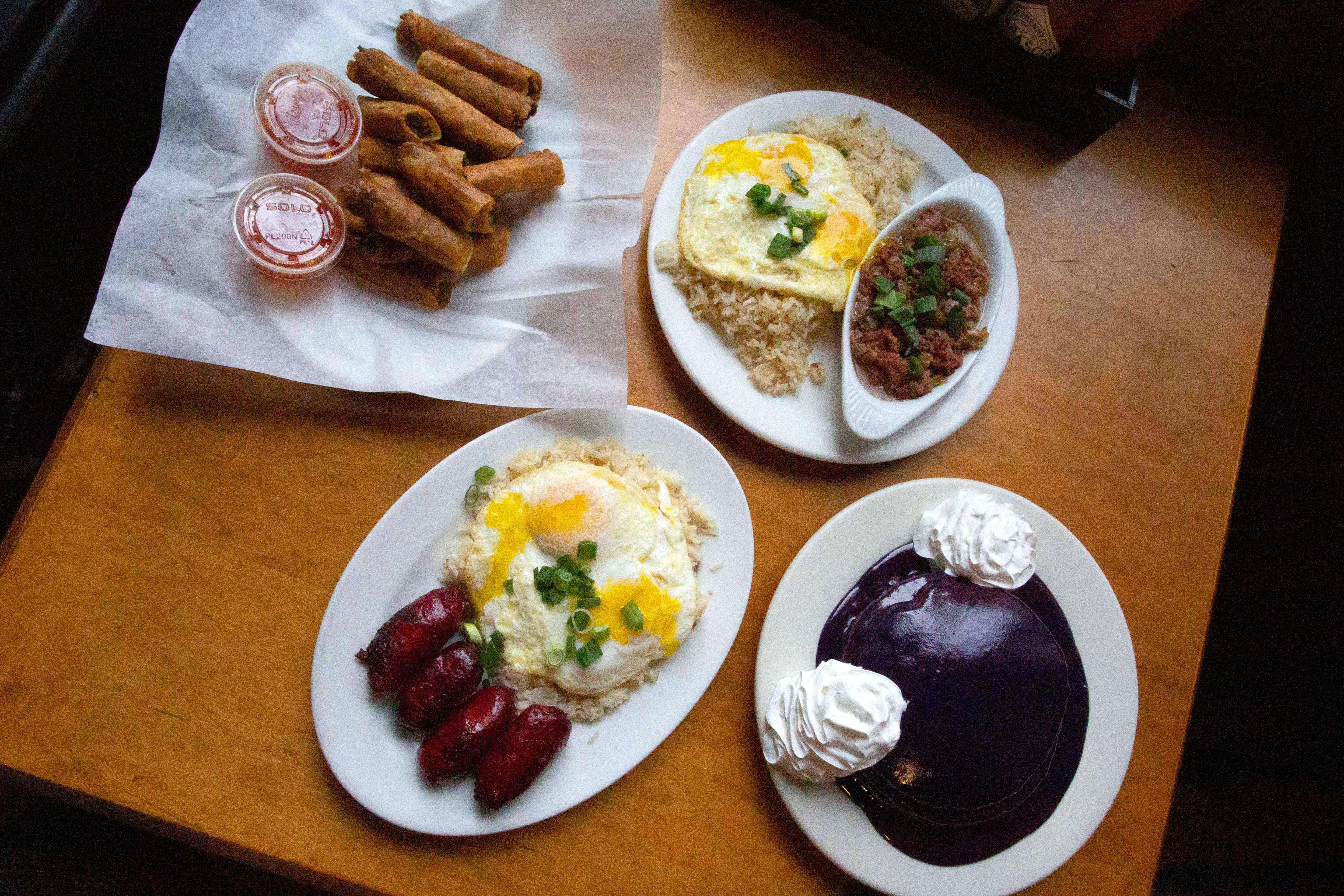 A bird’s eye view of various Filipino breakfast dishes at Ludi’s Restaurant and Lounge, including ube pancakes and corned beef silog.