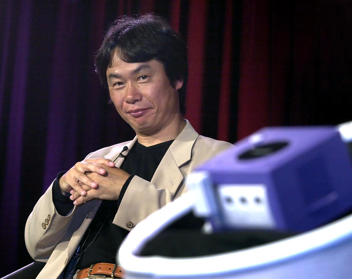 Shigeru Miyamoto looking at the Nintendo Gamecube, foreground, during the console’s reveal in May 2001