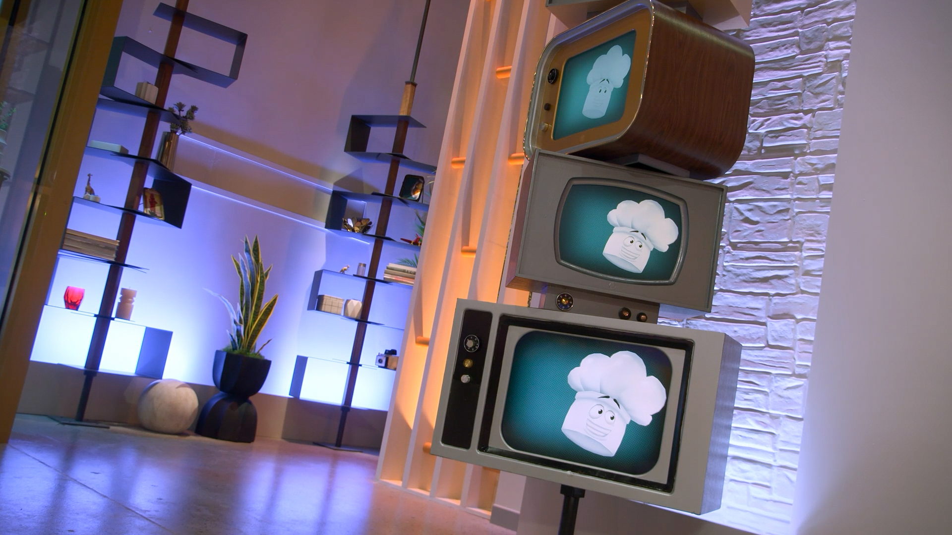 Three TVs stacked with an animated chef’s hat