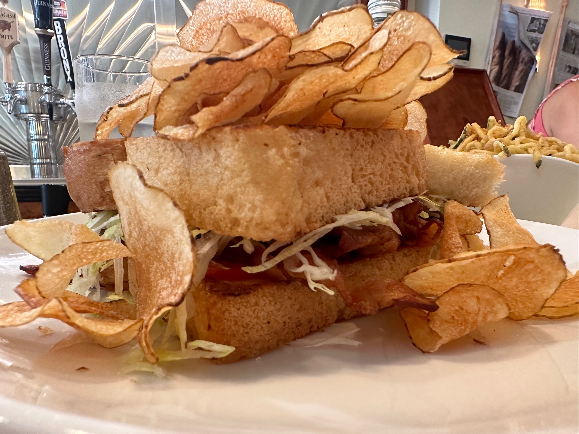 A BLT topped with potato chips. 