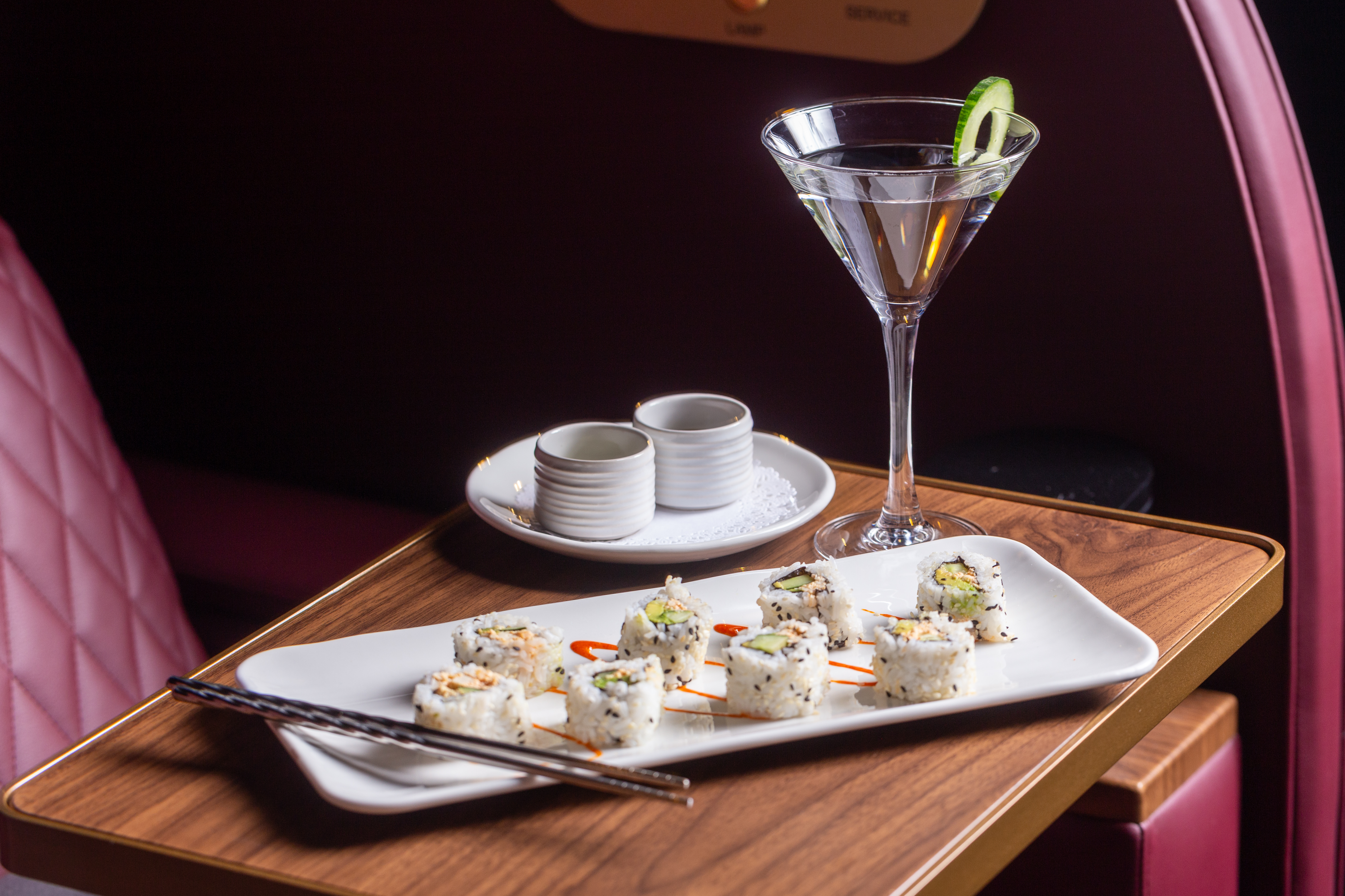 A martini and a sushi roll at a swivel table within a pod at Reel Luxury Cinemas in the Woodlands.