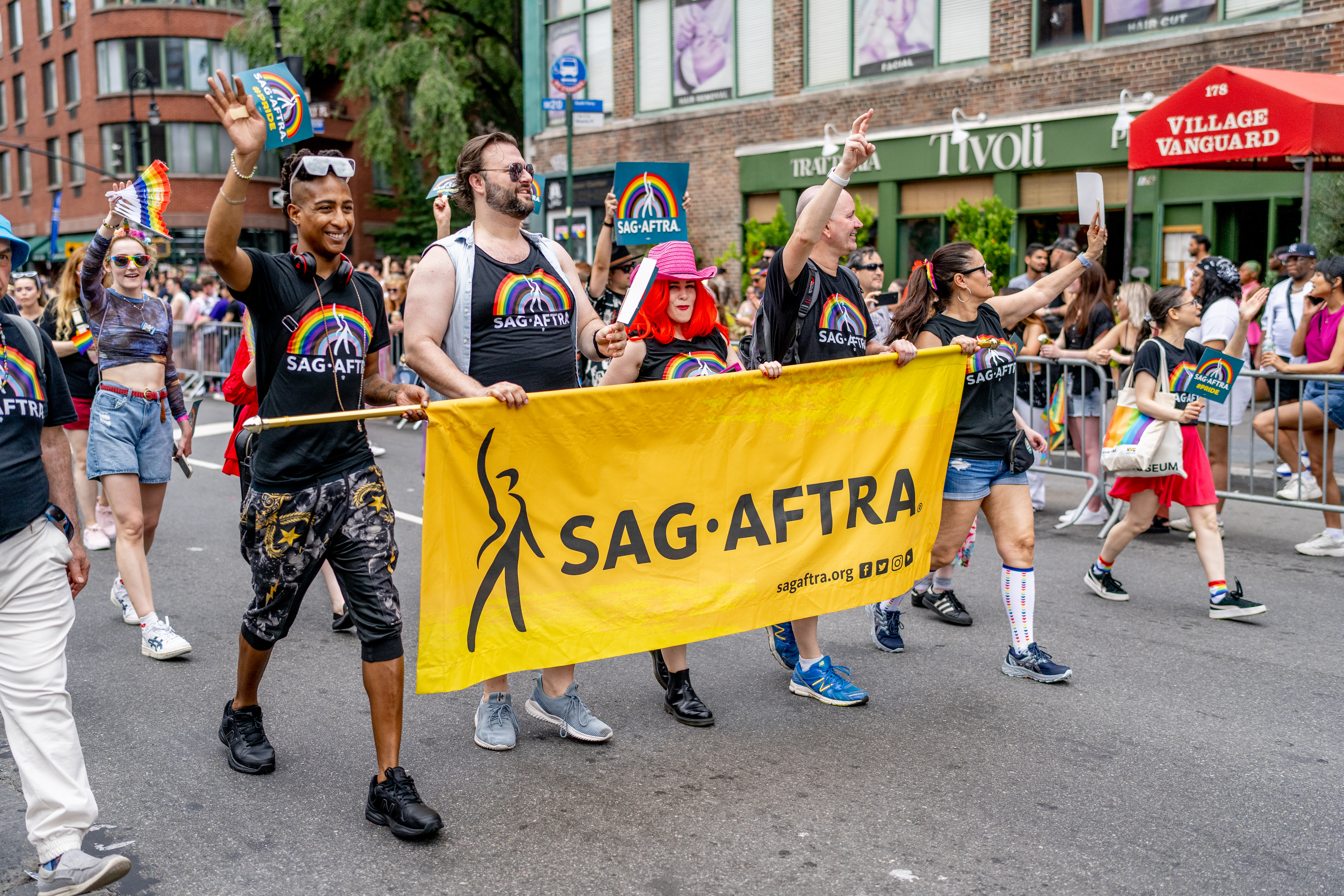 Several people march behind a SAG-AFTRA banner at 2023 New York City Pride March