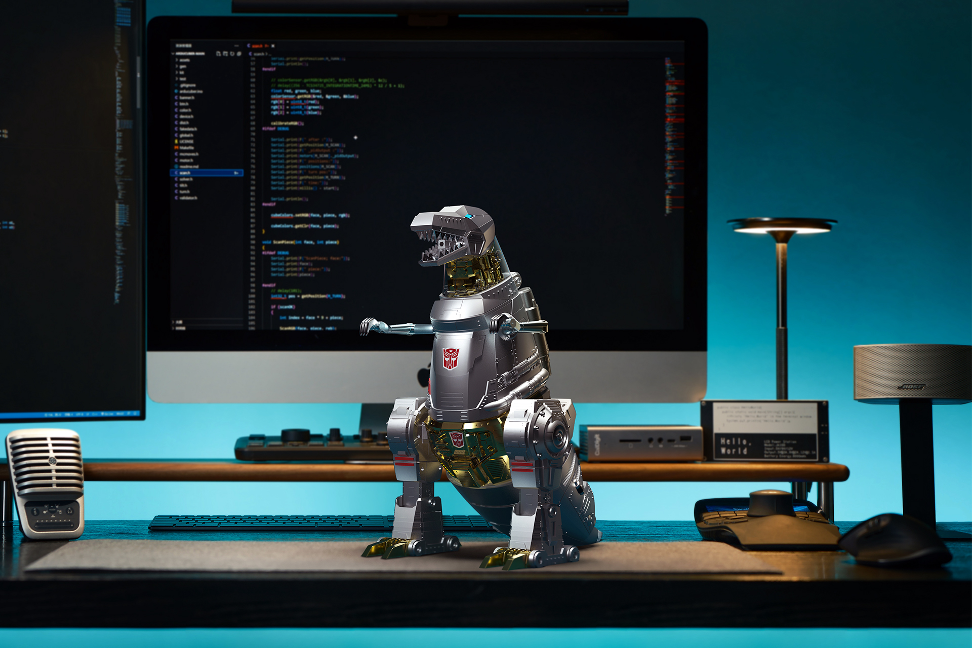 Robosen’s Grimlock Transformers toy standing on a desk with dual monitors and computer accessories