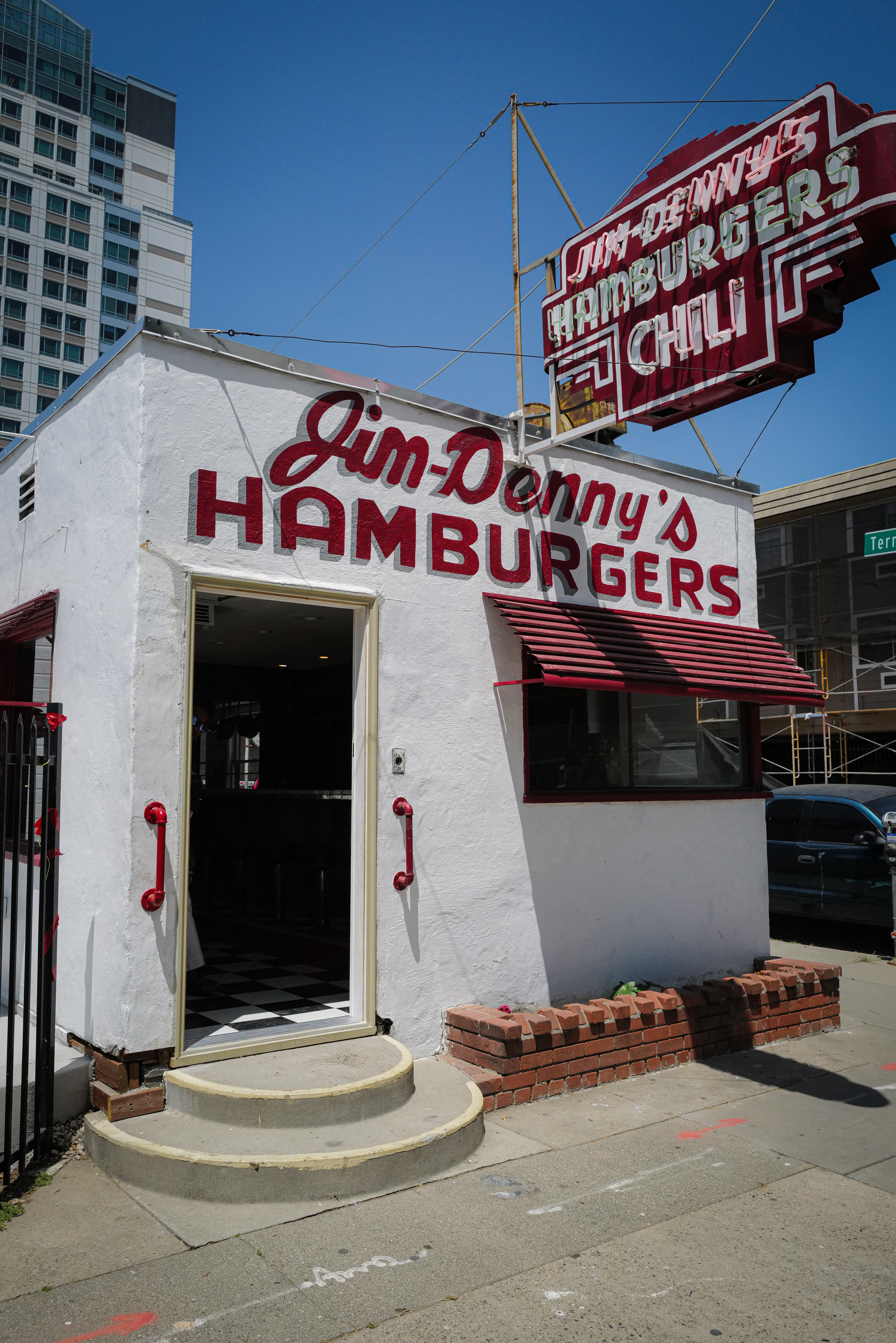 The exterior of a red and white building with a sign that reads Jim Denny’s.