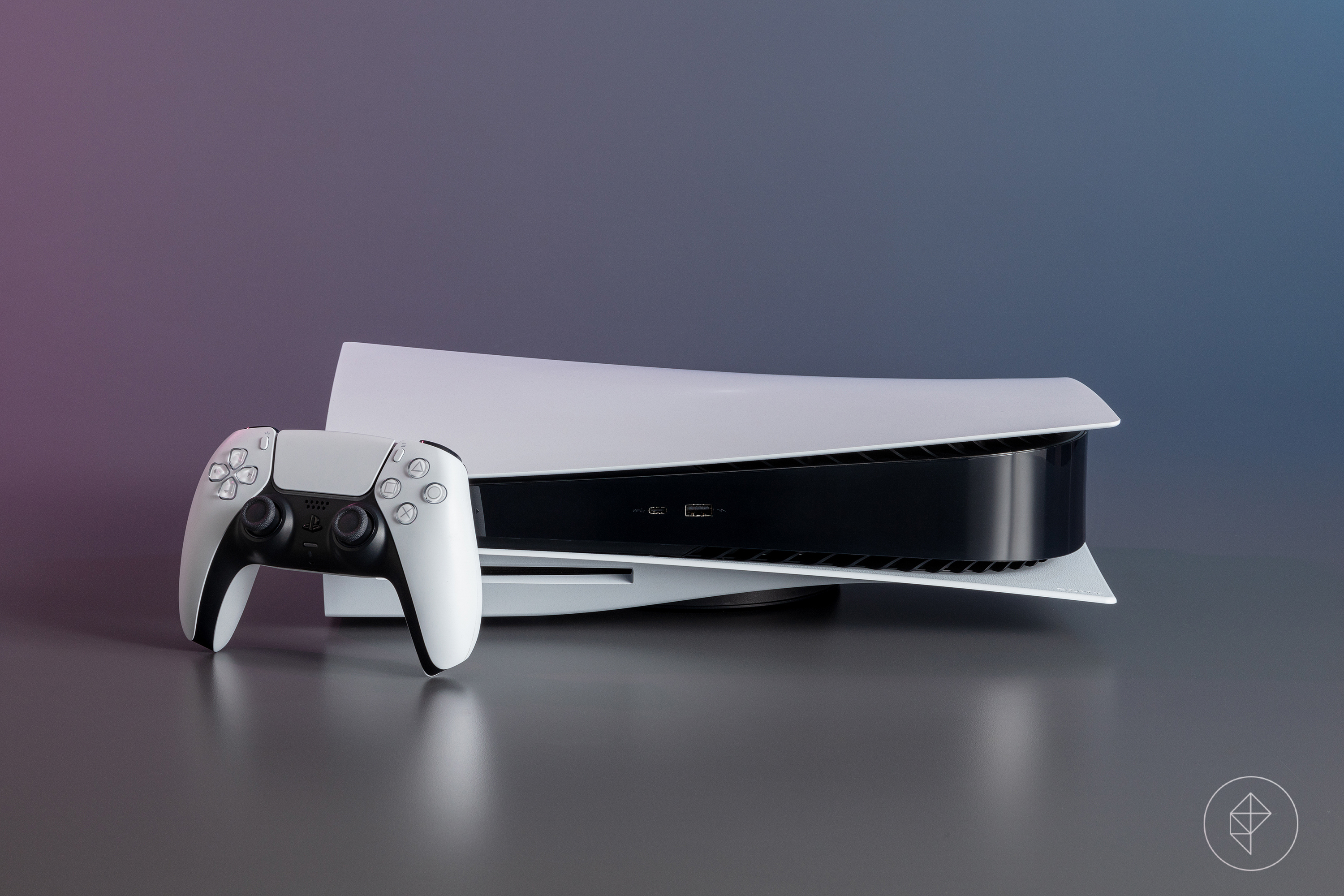 A photo of the standard PlayStation 5 console with a DualSense controller leaning against it