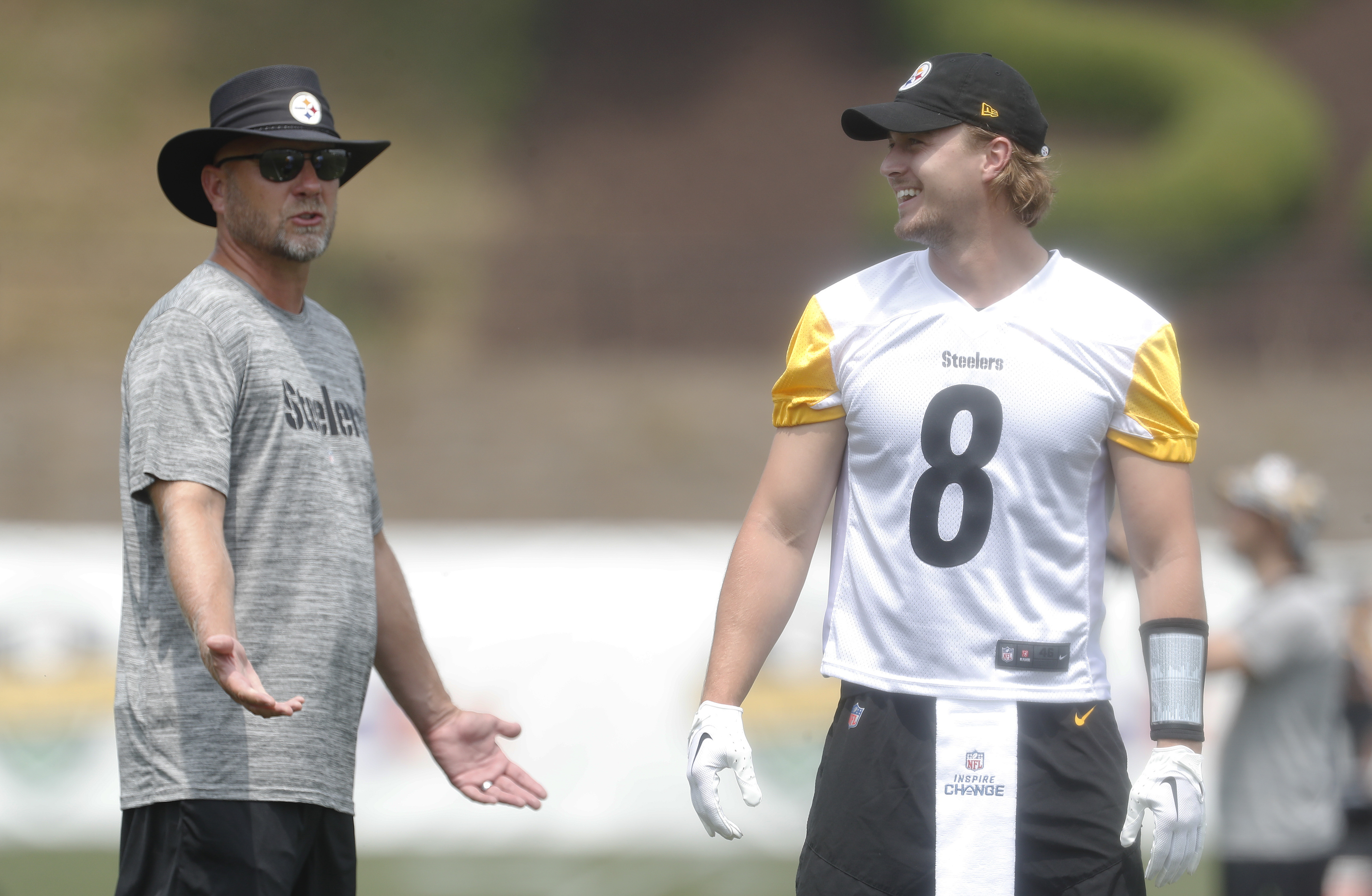 Pittsburgh Steelers offensive coordinator Matt Canada (left) instructs quarterback Kenny Pickett (8) in drills during training camp at Saint Vincent College.