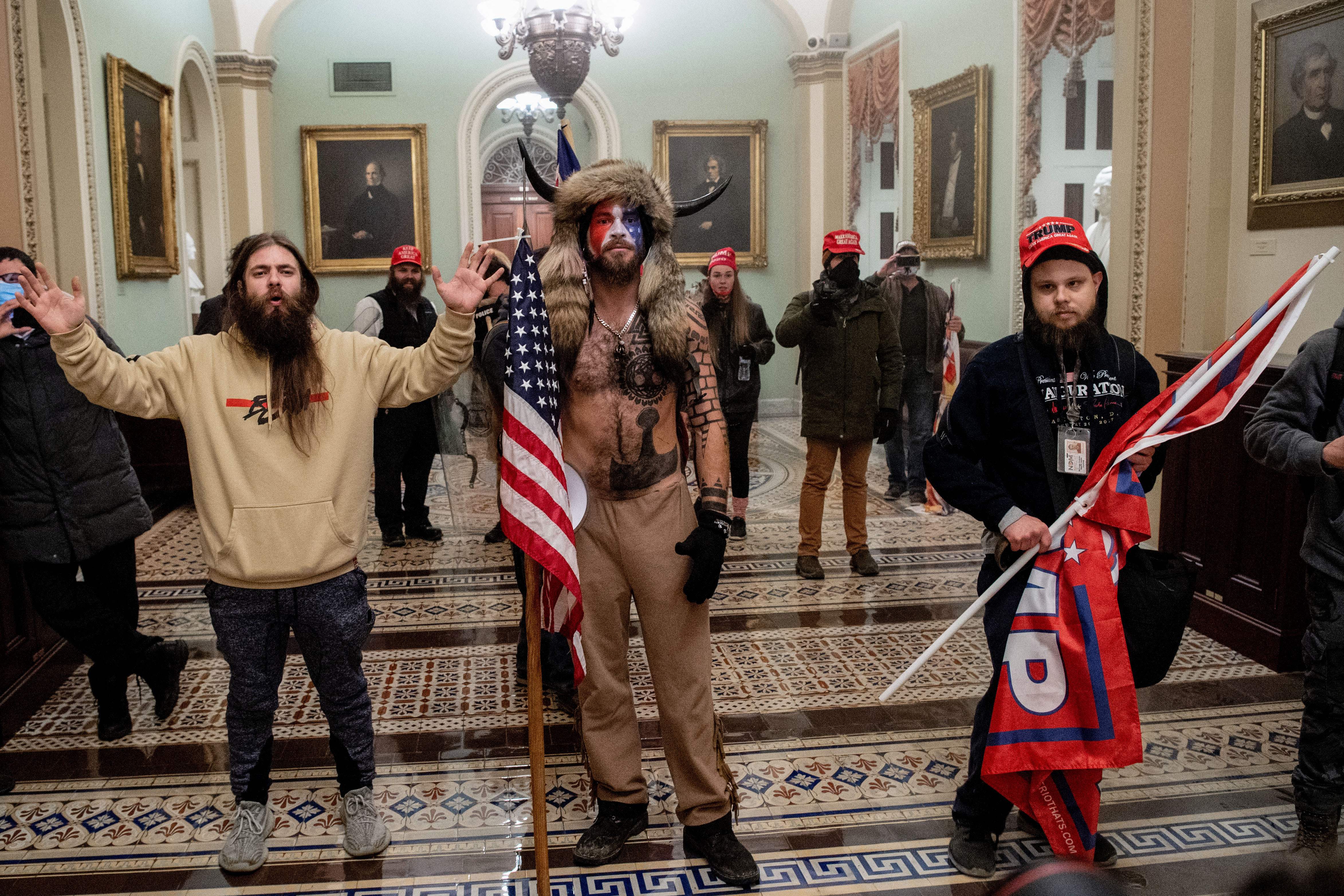 Insurrectionists posing inside the Capitol building on January 6, 2021.