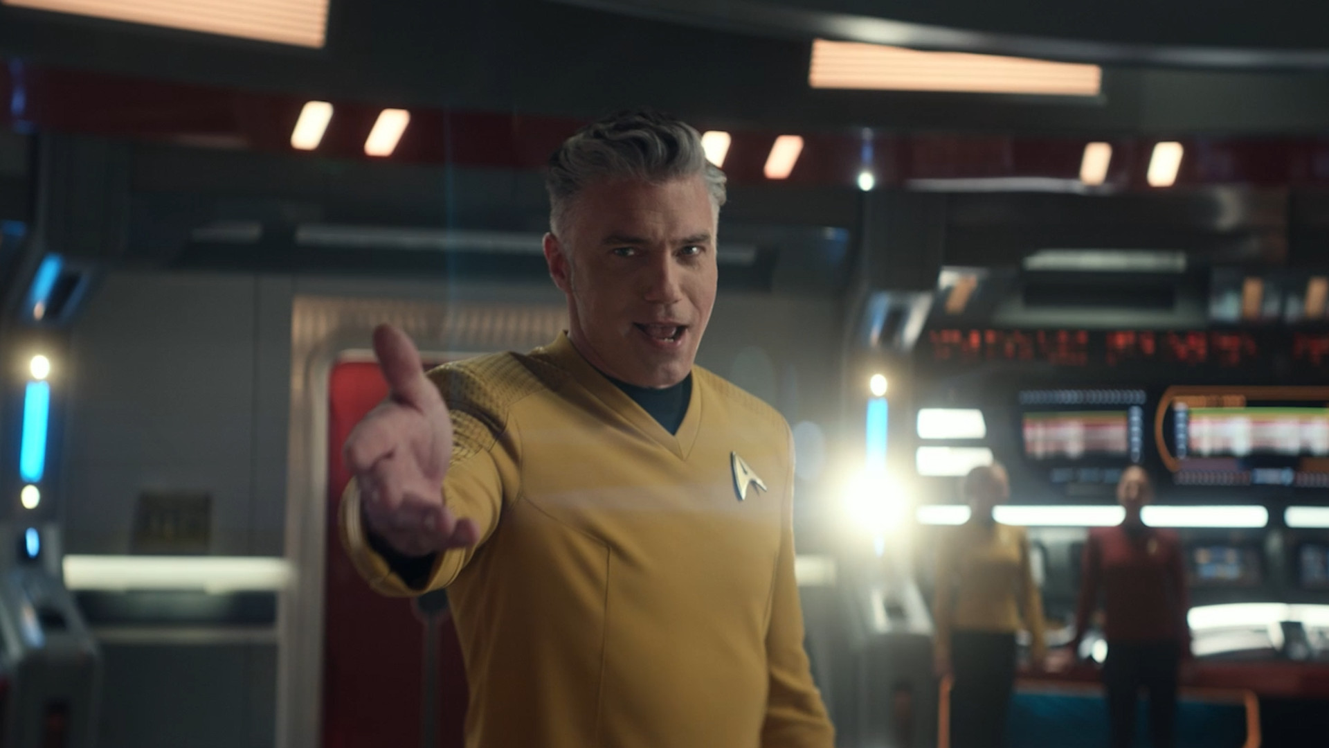 Pike (Anson Mount) holding his hand out and singing on the bridge of the Enterprise
