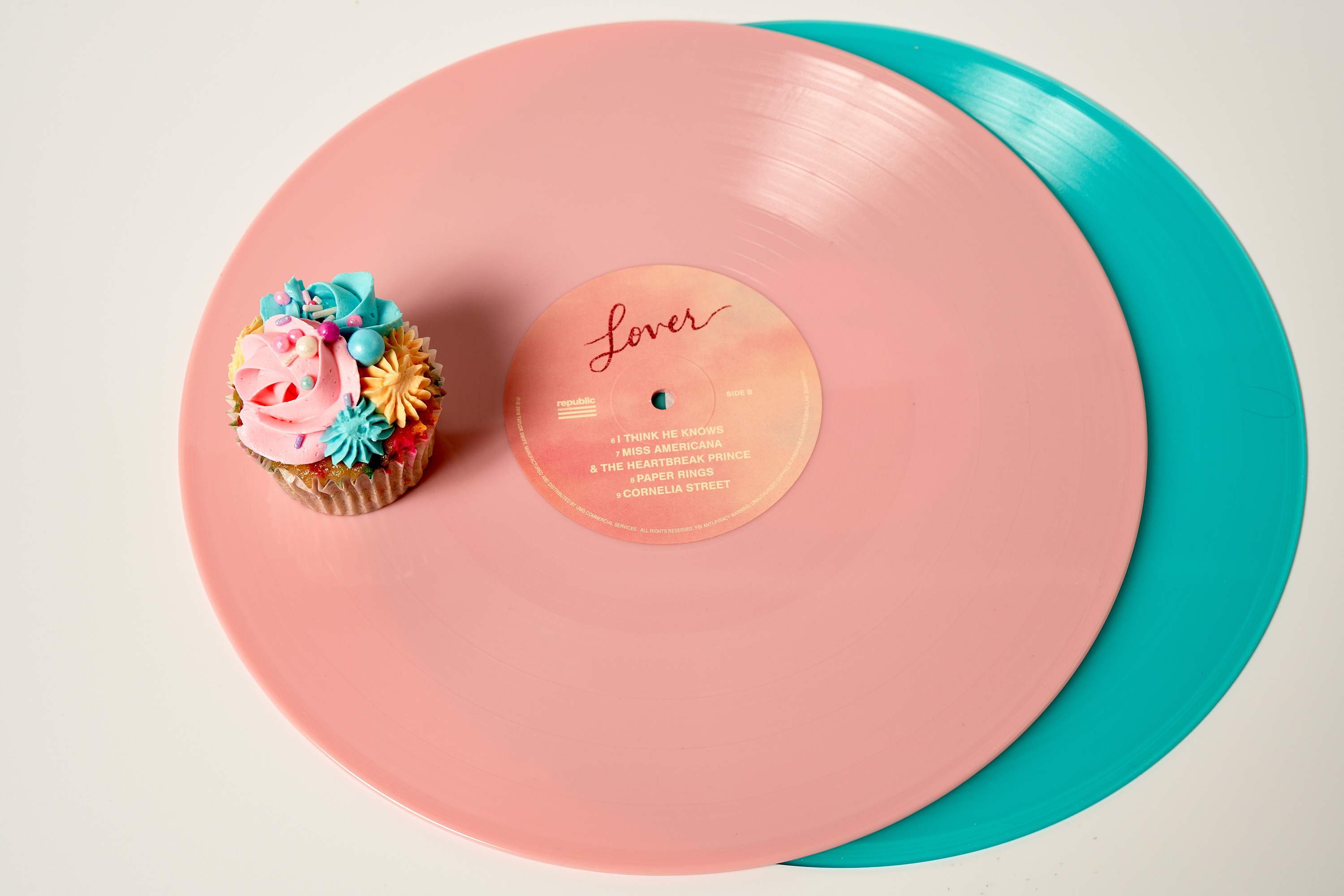 Bakery Sweet Lady Jane makes a pastel-toned cupcake and has it resting on a pink and teal record of Taylor Swift music.