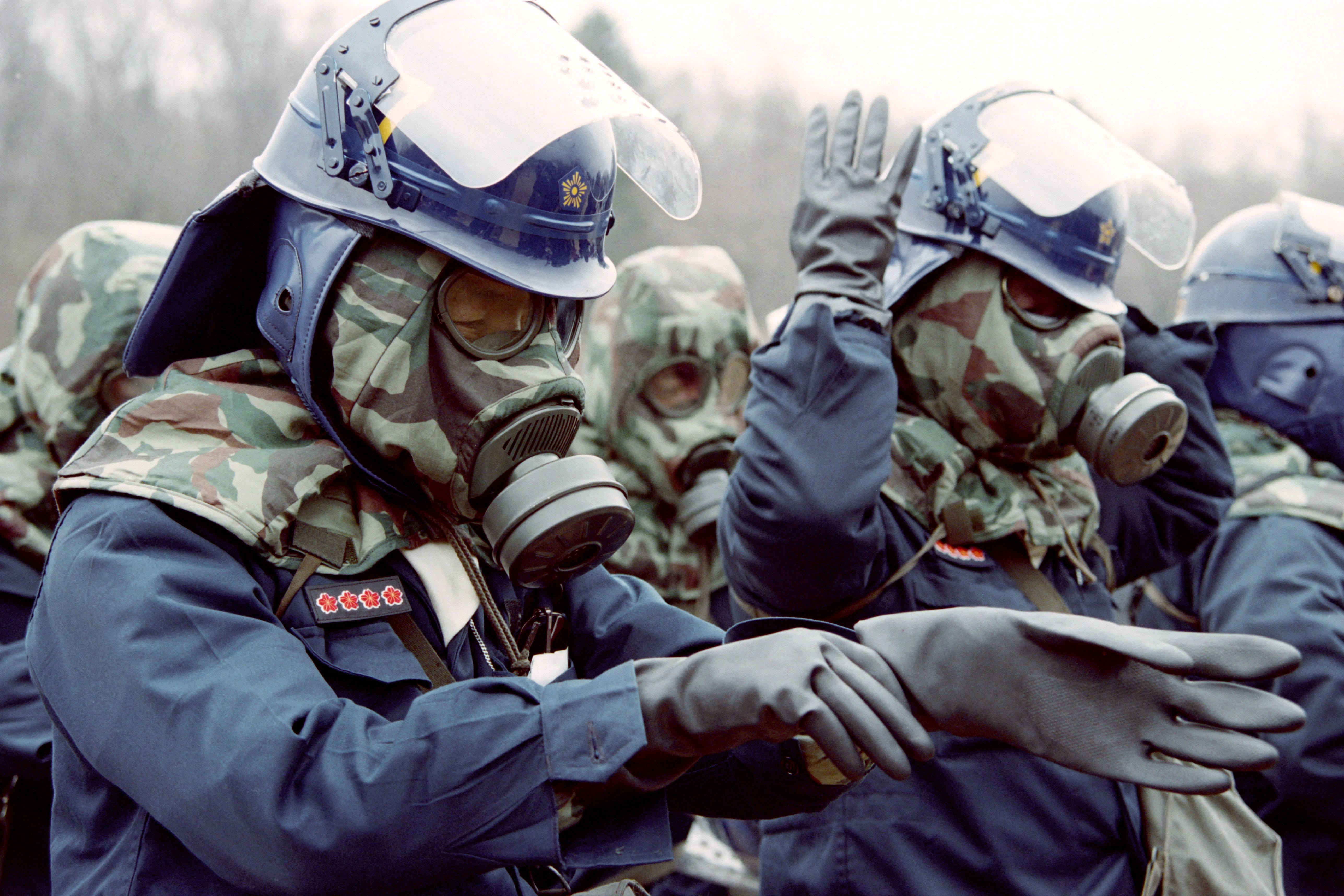 People wearing gas masks and anti-chemical gloves.
