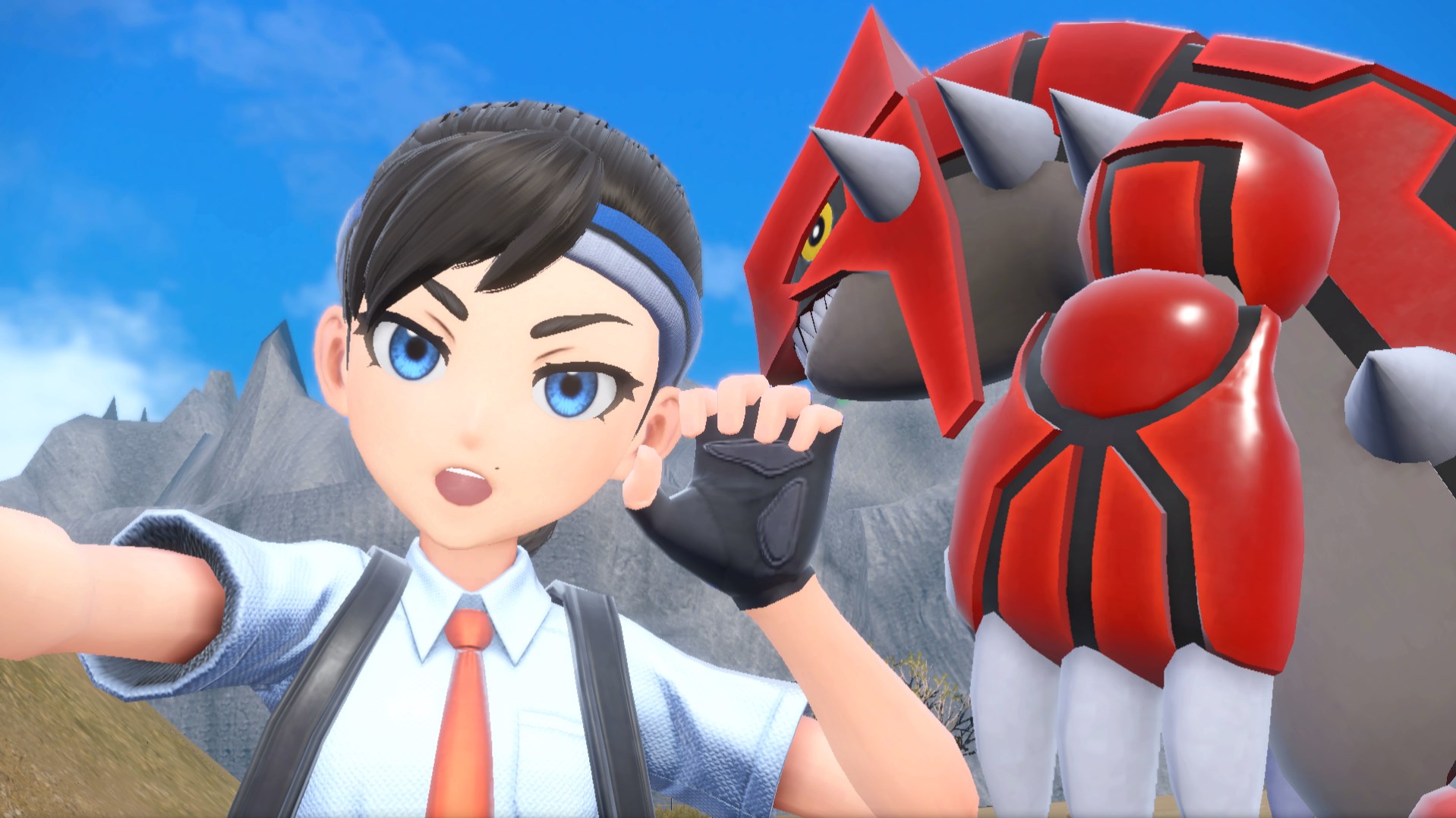A Pokémon trainer from Scarlet and Violet poses with a Groudon in the background