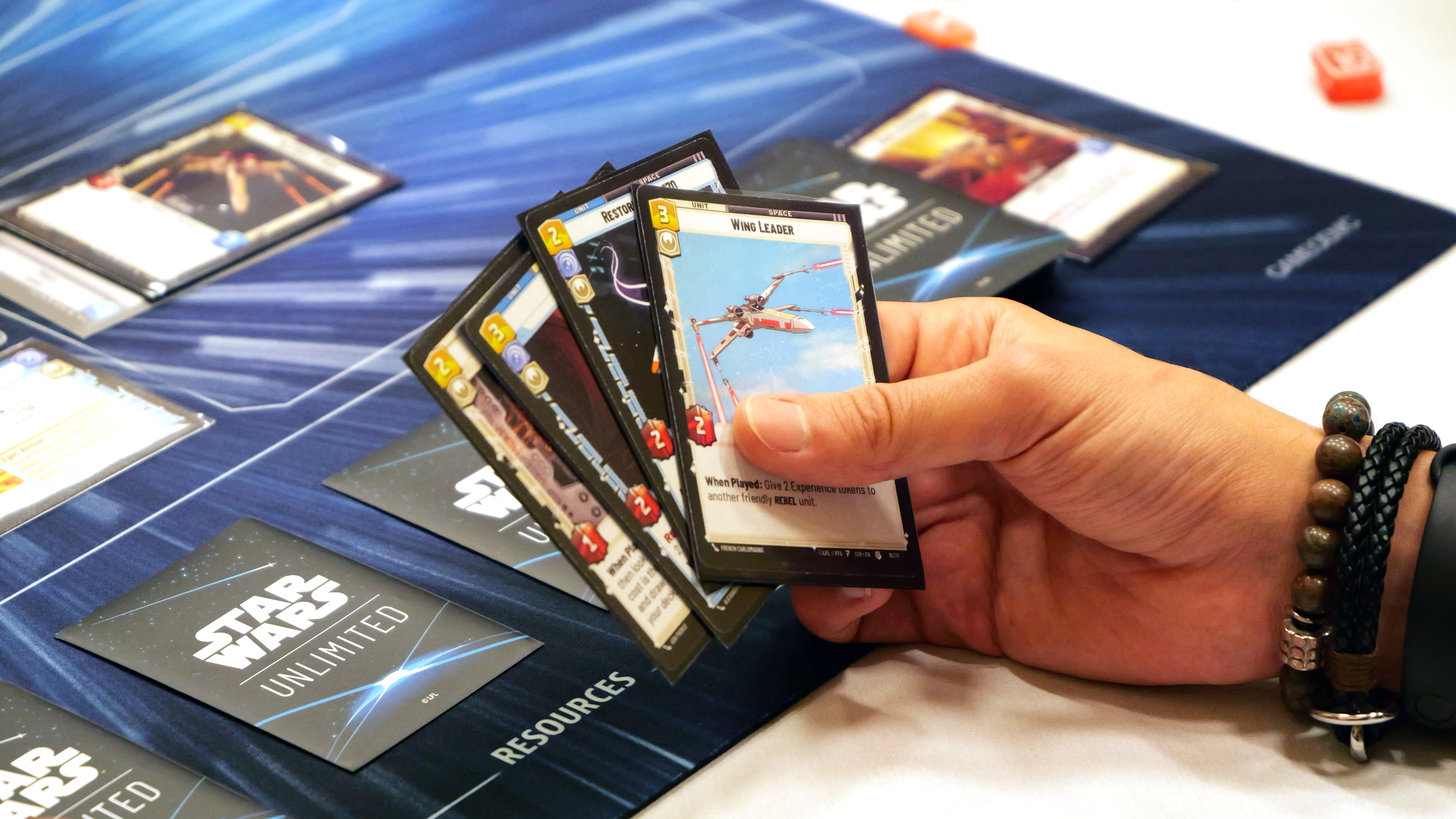 A player holding a small hand of cards from Star Wars: Unlimited during a demo event at Gen Con 2023.