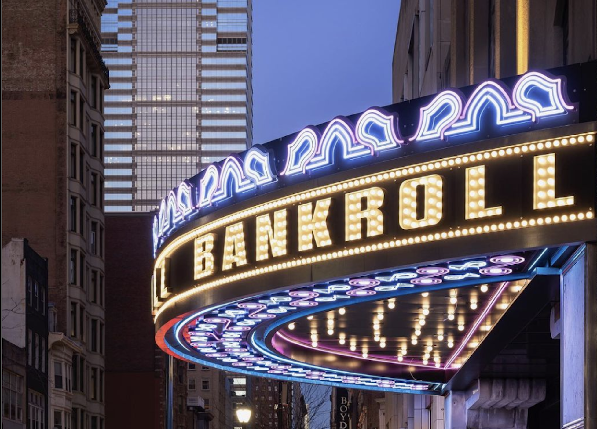 A lighted venue sign that displaces the name “Bankroll” across in the evening. 