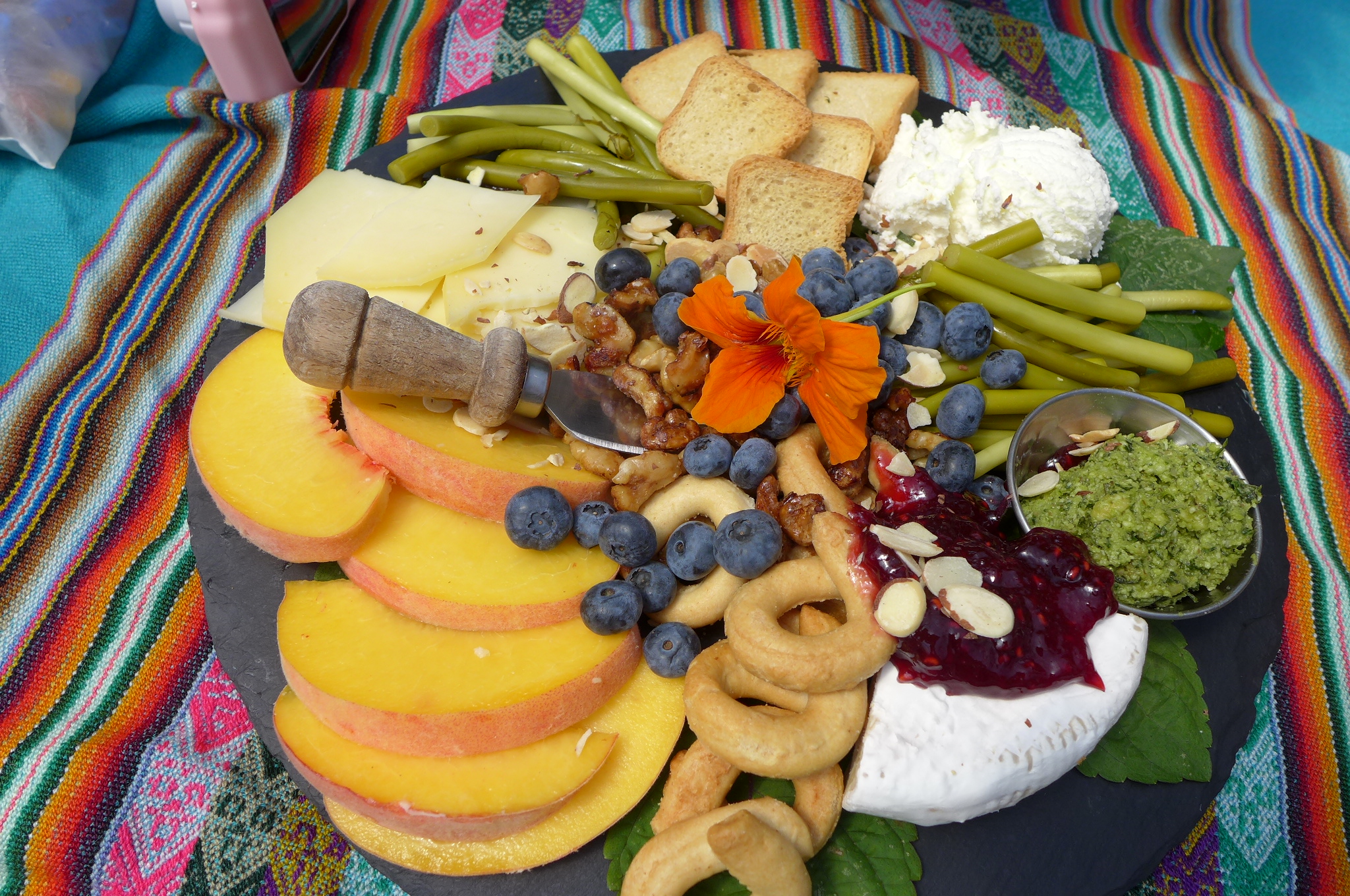 A profusion of flowers, fruit, nuts, and cheese.