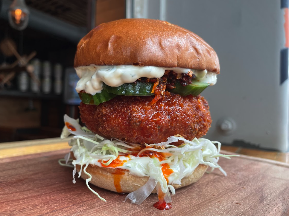 A fried shrimp patty on a bun with cabbage.