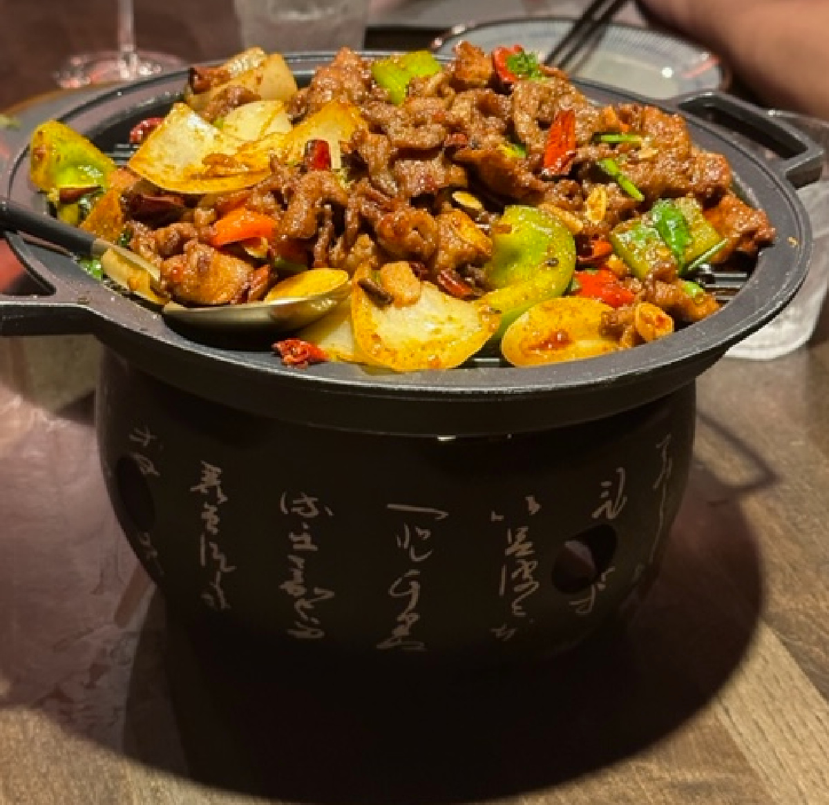 Beef, peppers, onion, and other items in a dry hotpot.