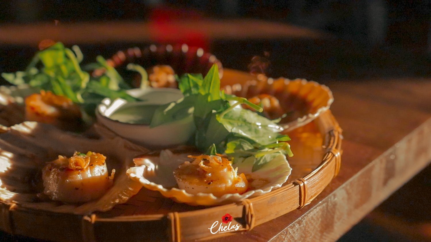 A bamboo plate with scallops served in seashells and garnished with greens. 