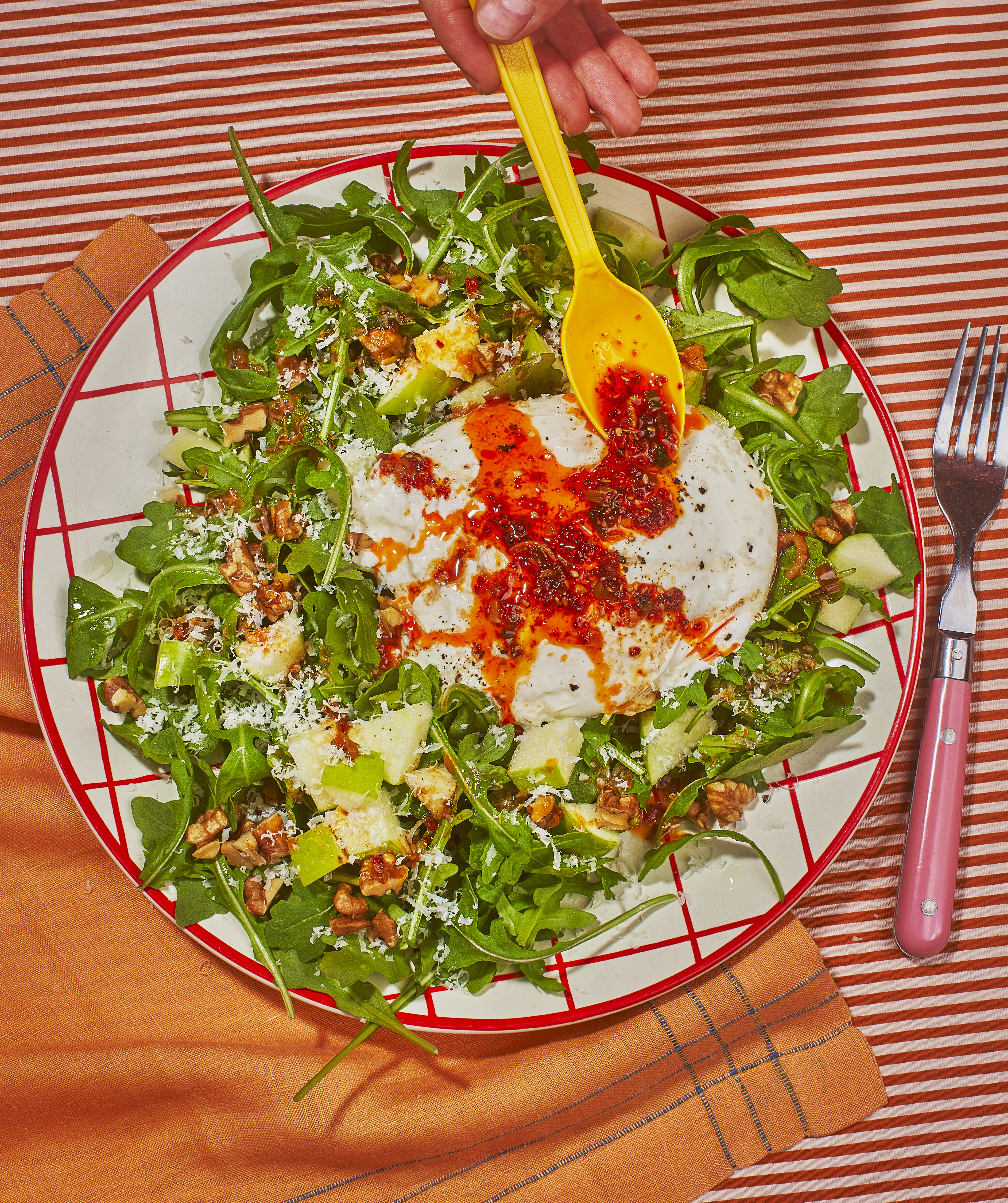 A salad with cheese topped with chile crisp. 