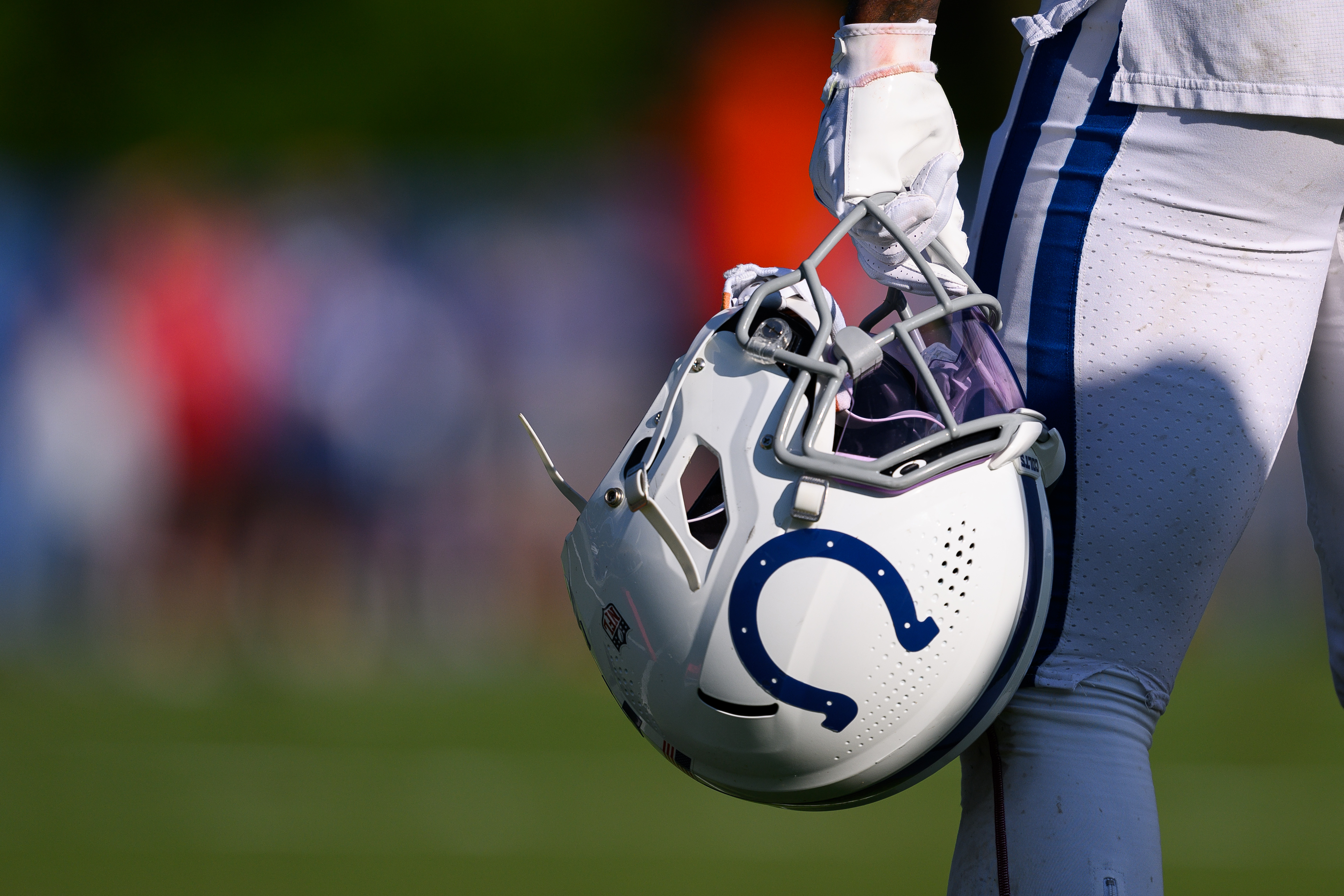 A Indianapolis Colts player holds a helmet on the sidelines during the Indianapolis Colts and Chicago Bears joint Training Camp practice on August 16, 2023 at the Grand Park Sports Campus in Westfield, IN.