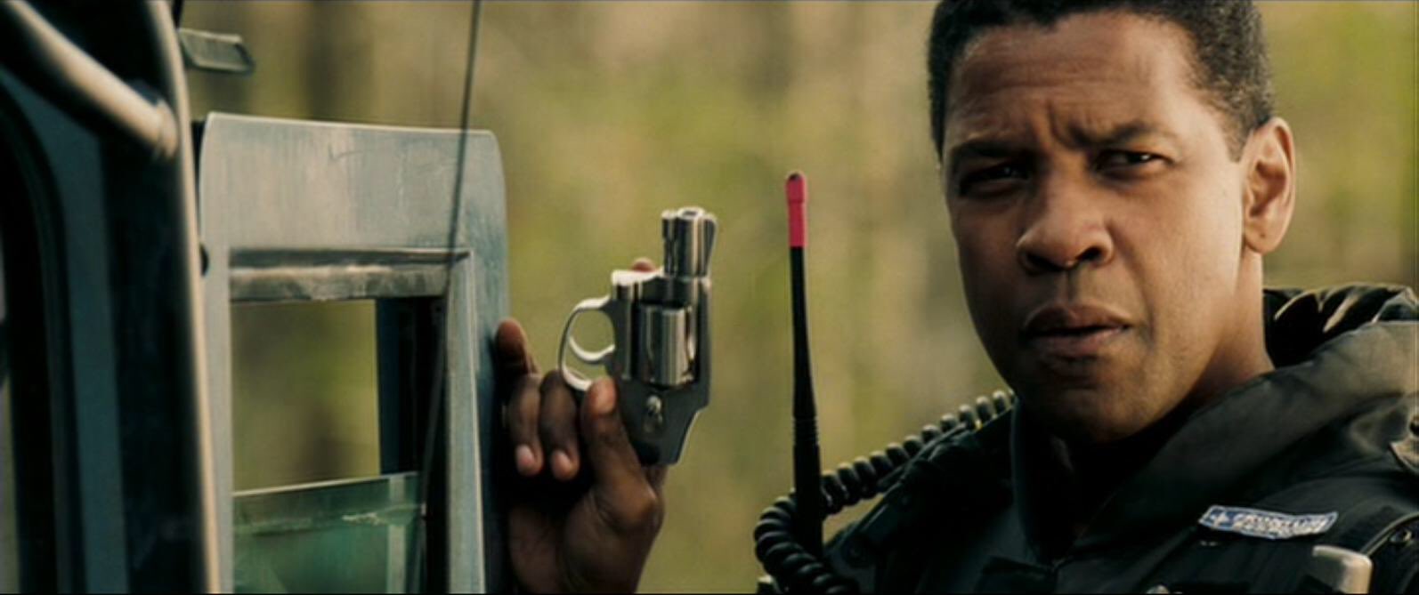 Denzel Washington as Doug Carlin holding a revolver in Deja Vu.