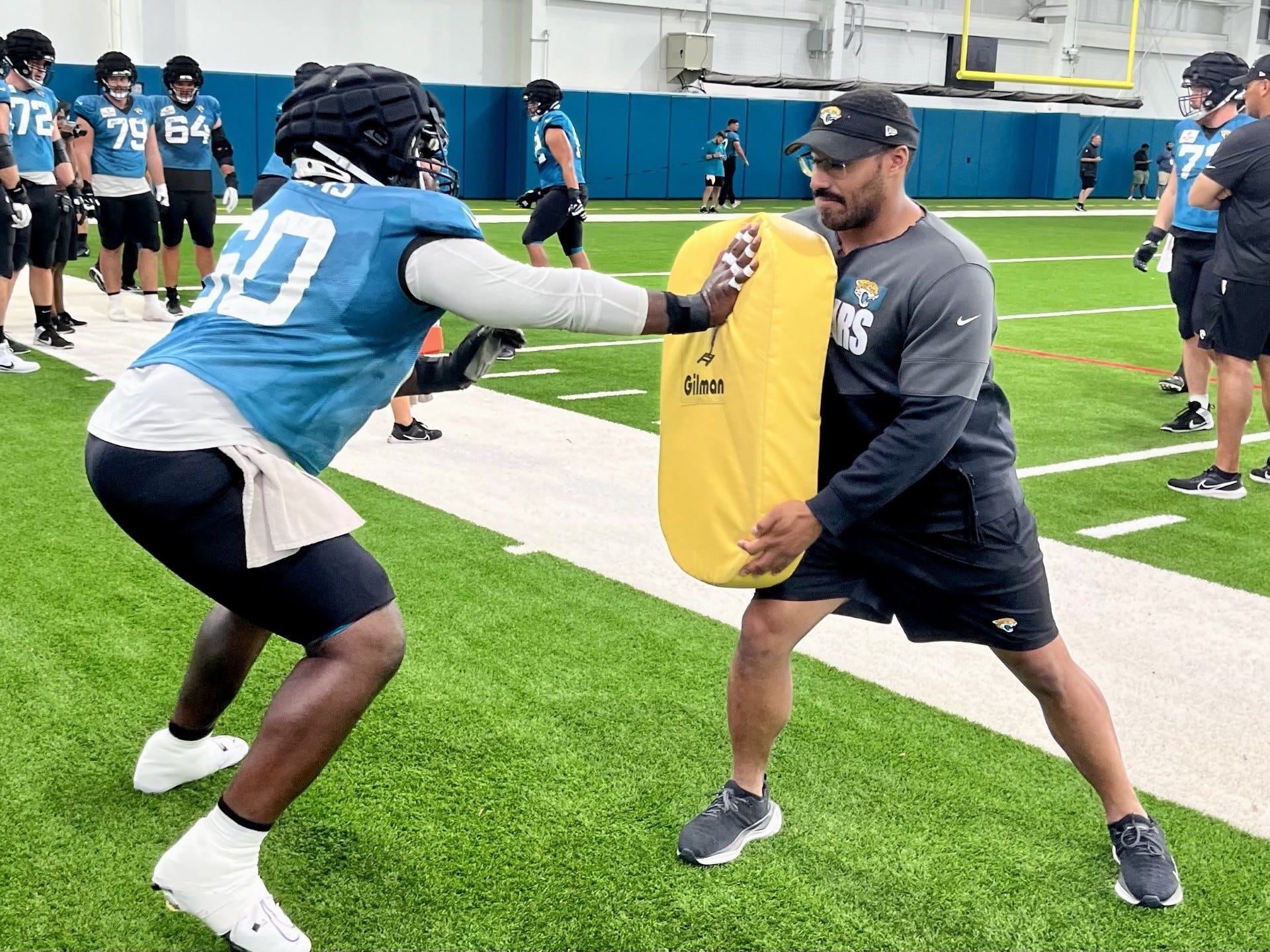 Jacksonville Jaguars center Darryl Williams works out individually with assistant strength coach Kevin Maxen.