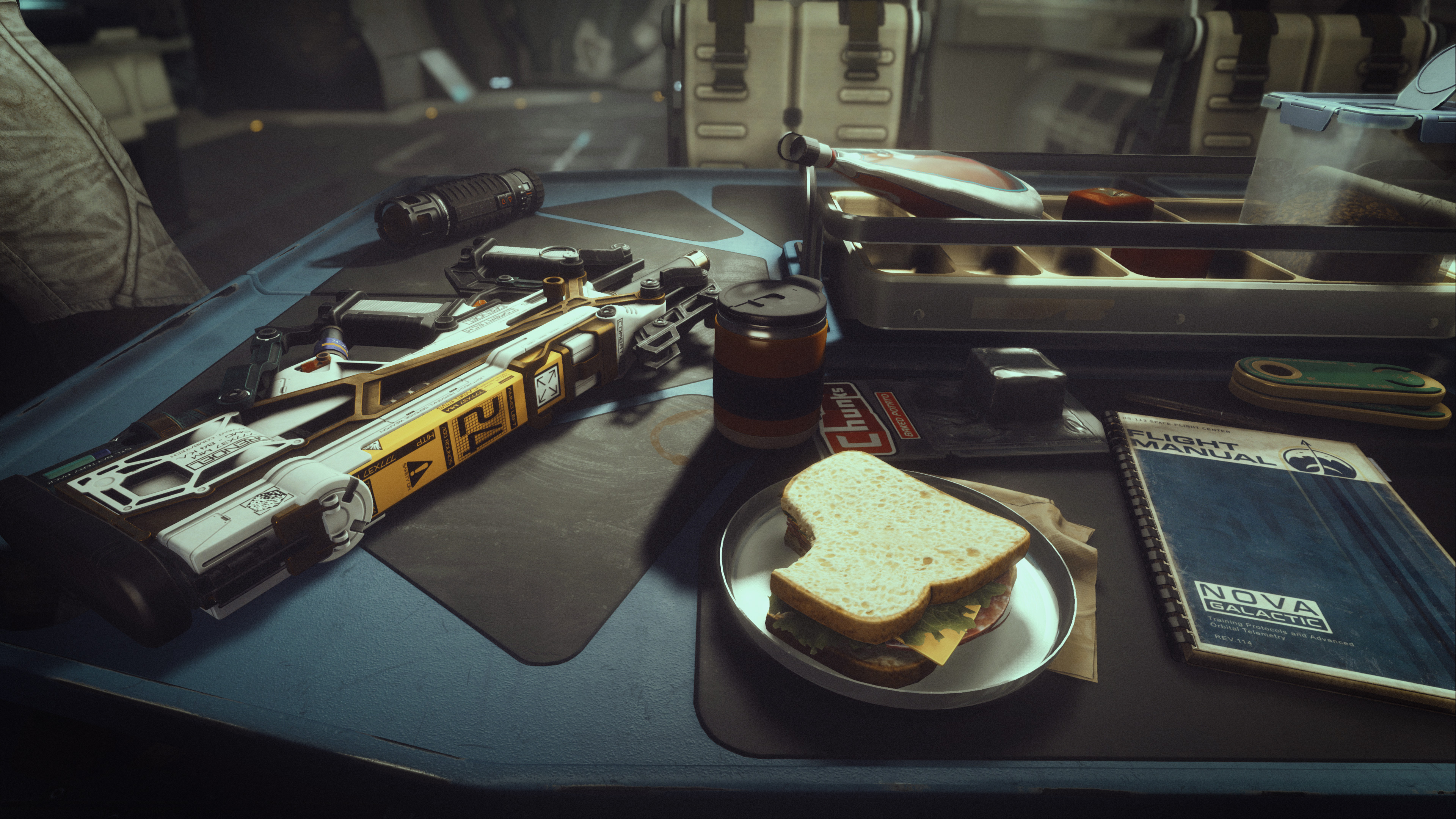 an assault rifle, a flight manual, a sandwich, and other sundry objects sitting on a desk in Starfield