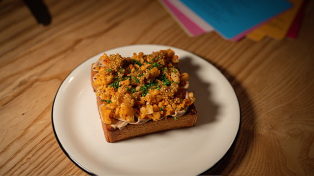 A piece of toast topped with piped chicken liver mousse and crispy bits.