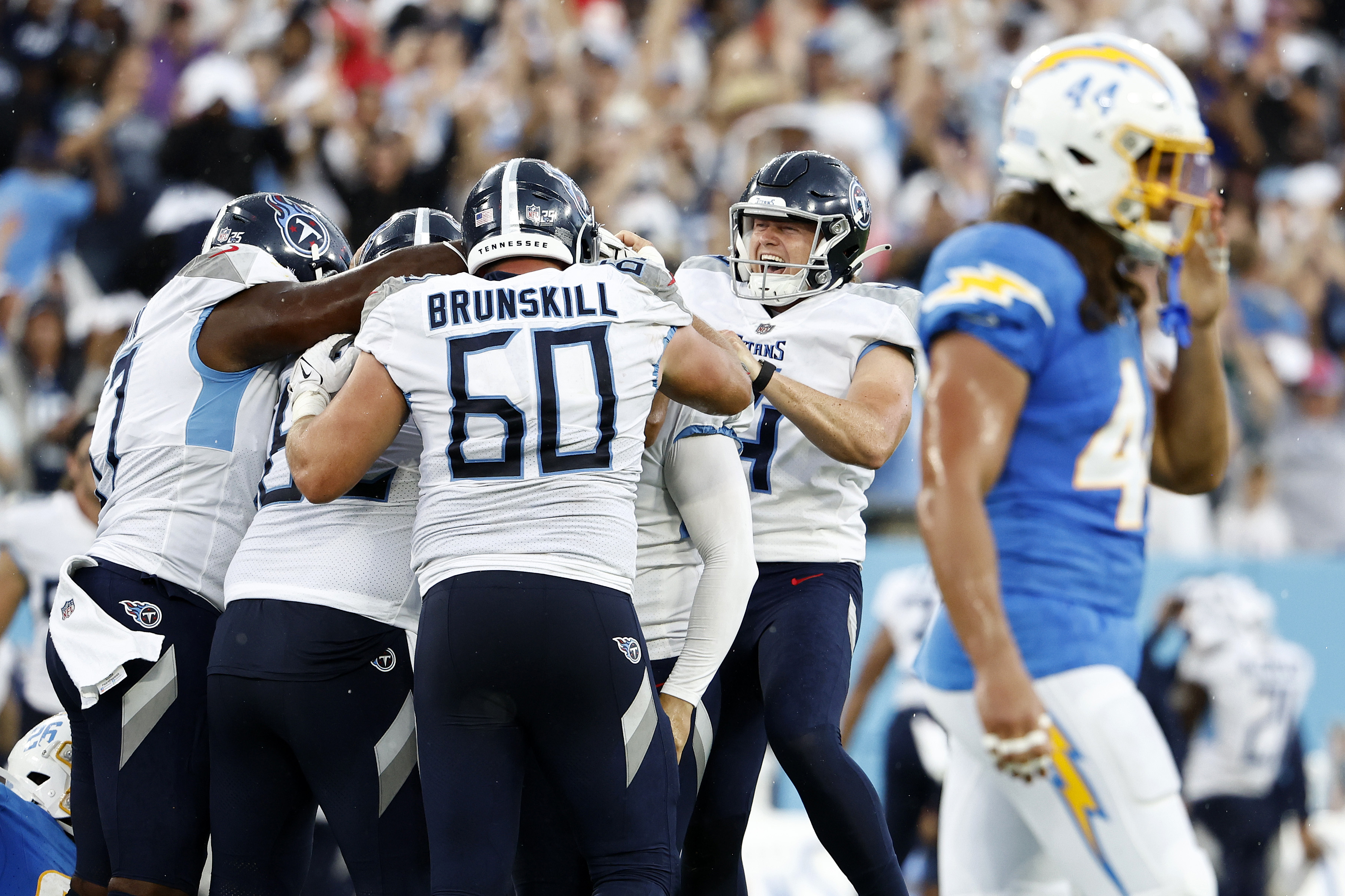 Ryan Stonehouse #4 of the Tennessee Titans joins teammates in celebrating a game winning field goal in overtime by Nick Folk #6 of the Tennessee Titans as Tanner Muse #44 of the Los Angeles Chargers walks off the field at Nissan Stadium on September 17, 2023 in Nashville, Tennessee.