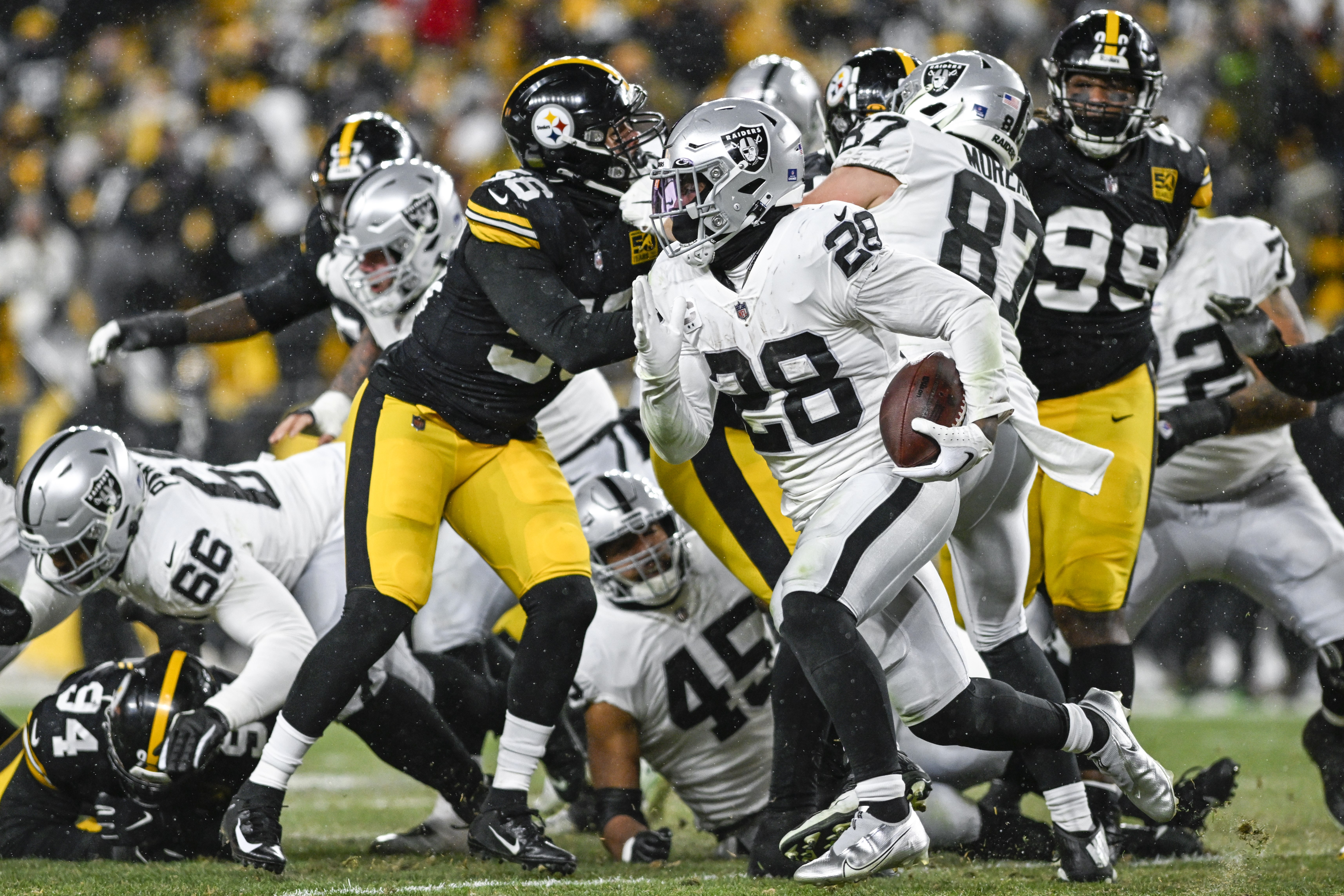 Josh Jacobs #28 of the Las Vegas Raiders runs the ball in the third quarter against the Pittsburgh Steelers at Acrisure Stadium on December 24, 2022 in Pittsburgh, Pennsylvania.