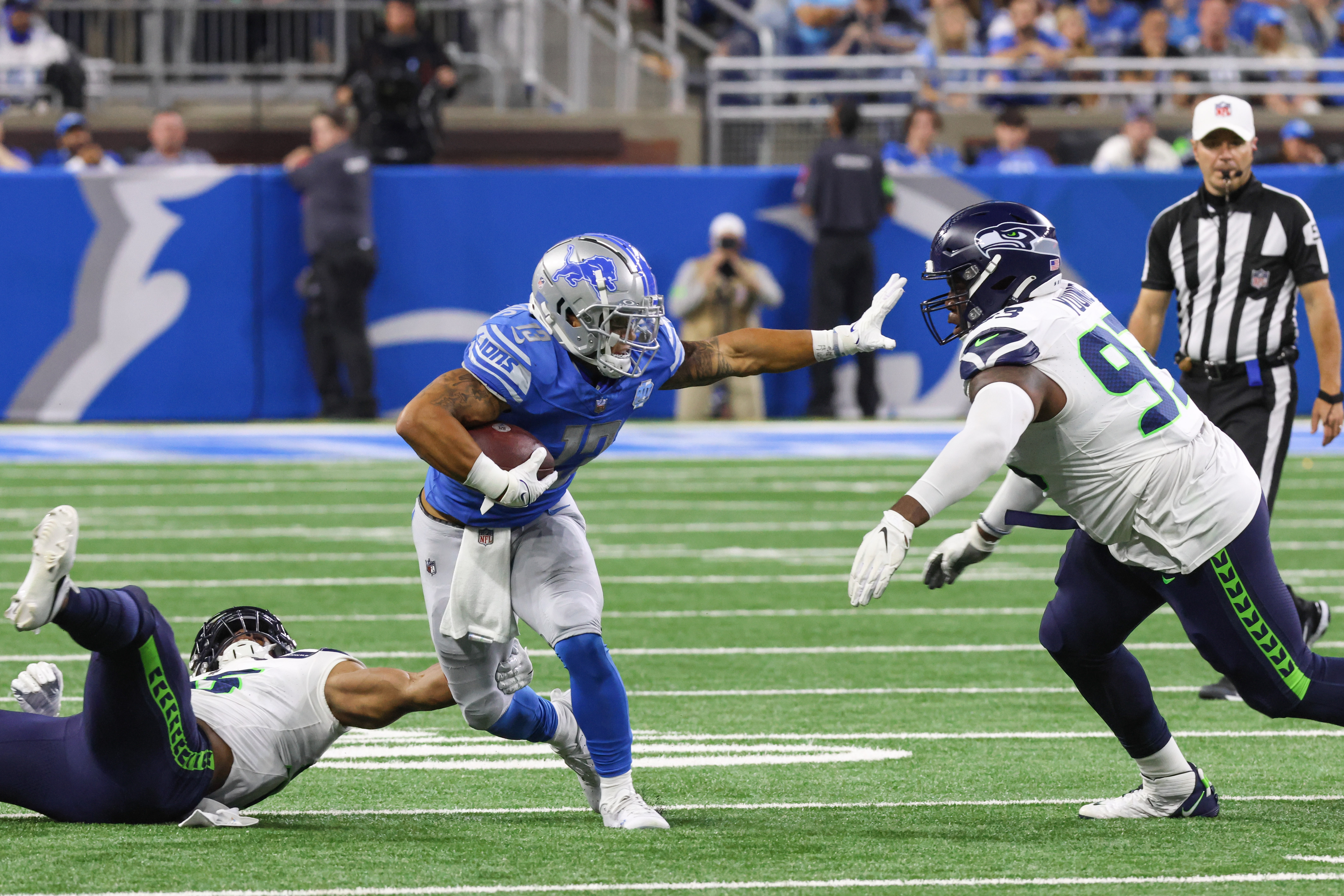 Detroit Lions running back Craig Reynolds runs with the ball while pushing Seattle Seahawks nose tackle Cameron Young away during the fourth quarter of an NFL football game between the Seattle Seahawks and the Detroit Lions on September 17, 2023 at Ford Field in Detroit, Michigan.