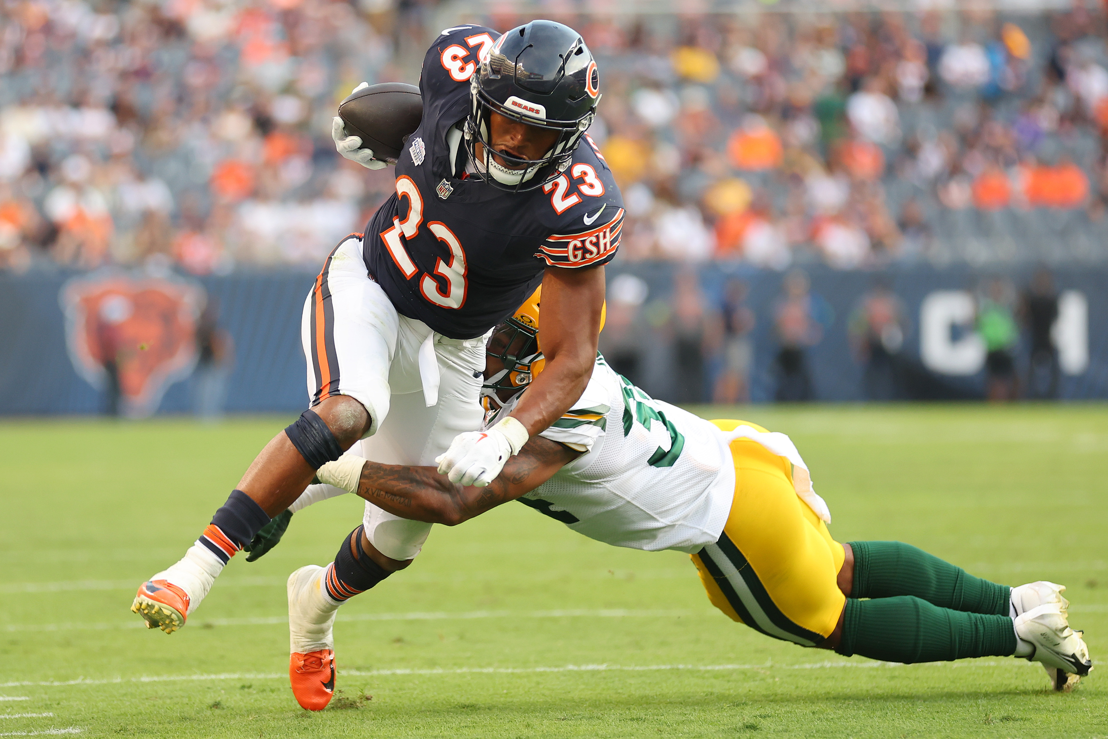 Roschon Johnson of the Chicago Bears breaks a tackle from Jonathan Owens of the Green Bay Packers during the fourth quarter at Soldier Field on September 10, 2023 in Chicago, Illinois.