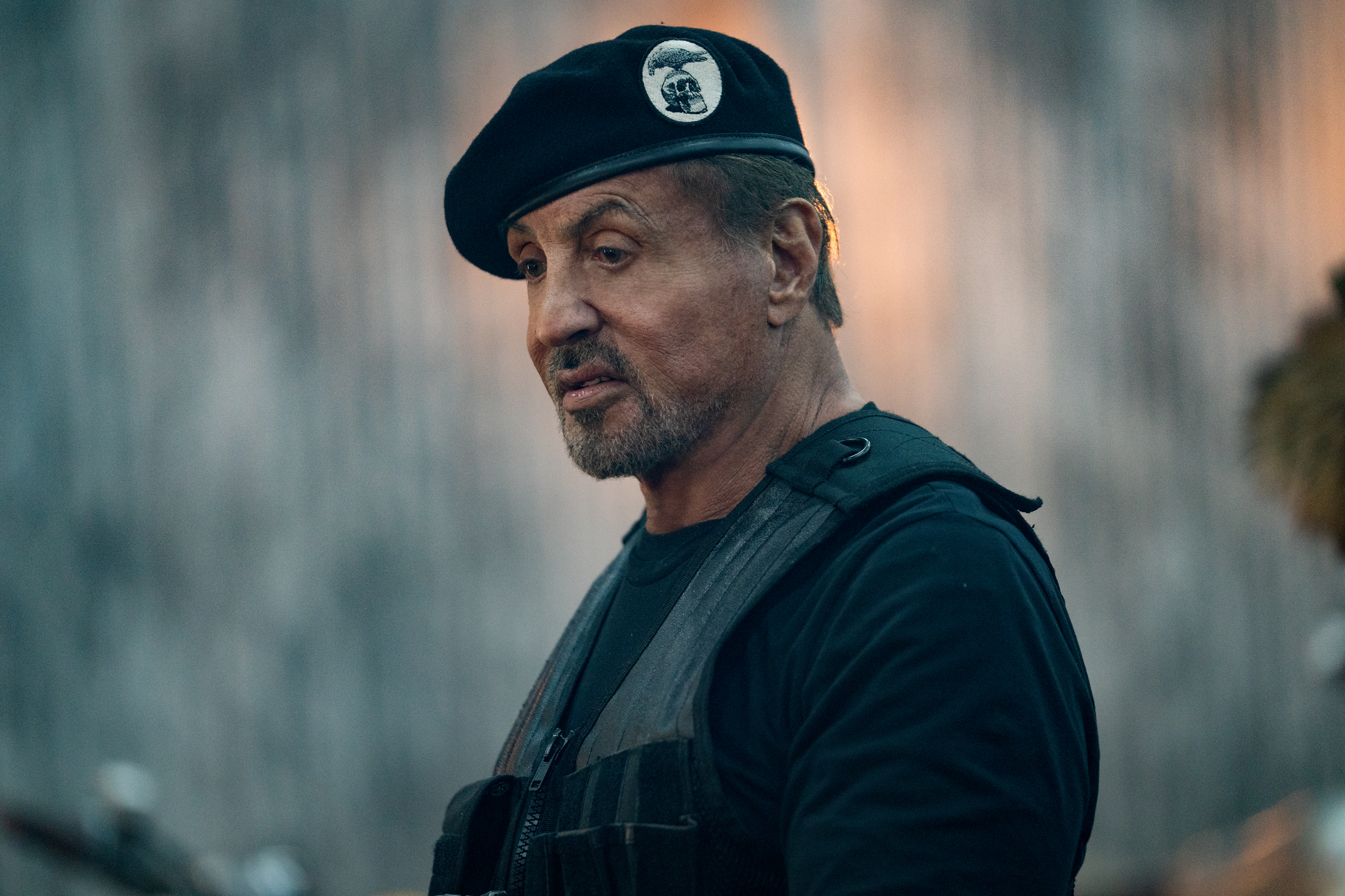 A midshot of Sylvester Stallone wearing a black beret and vest in the film Expend4bles.