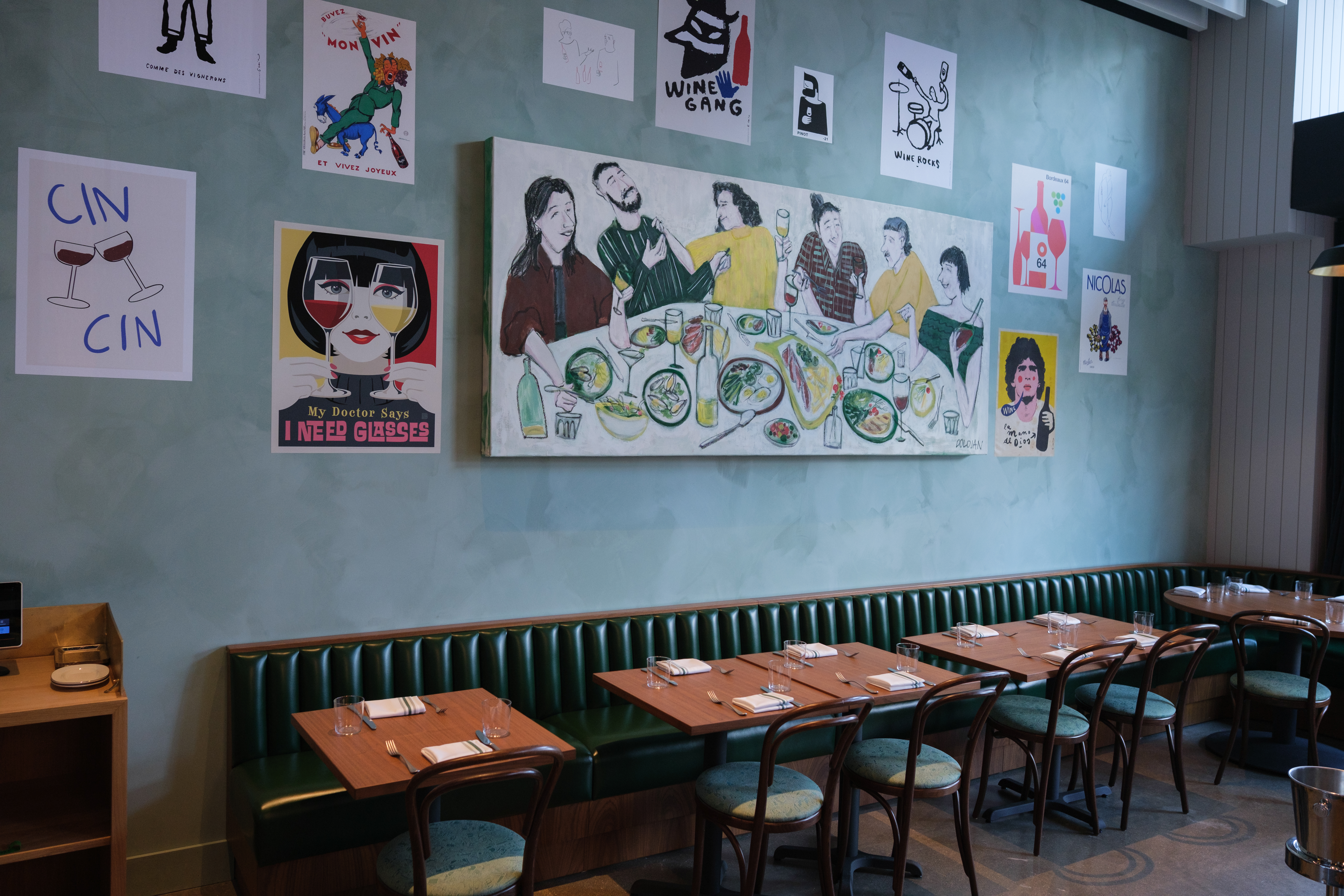 A portion of a bistro dining room with a large mural of people drinking wine.