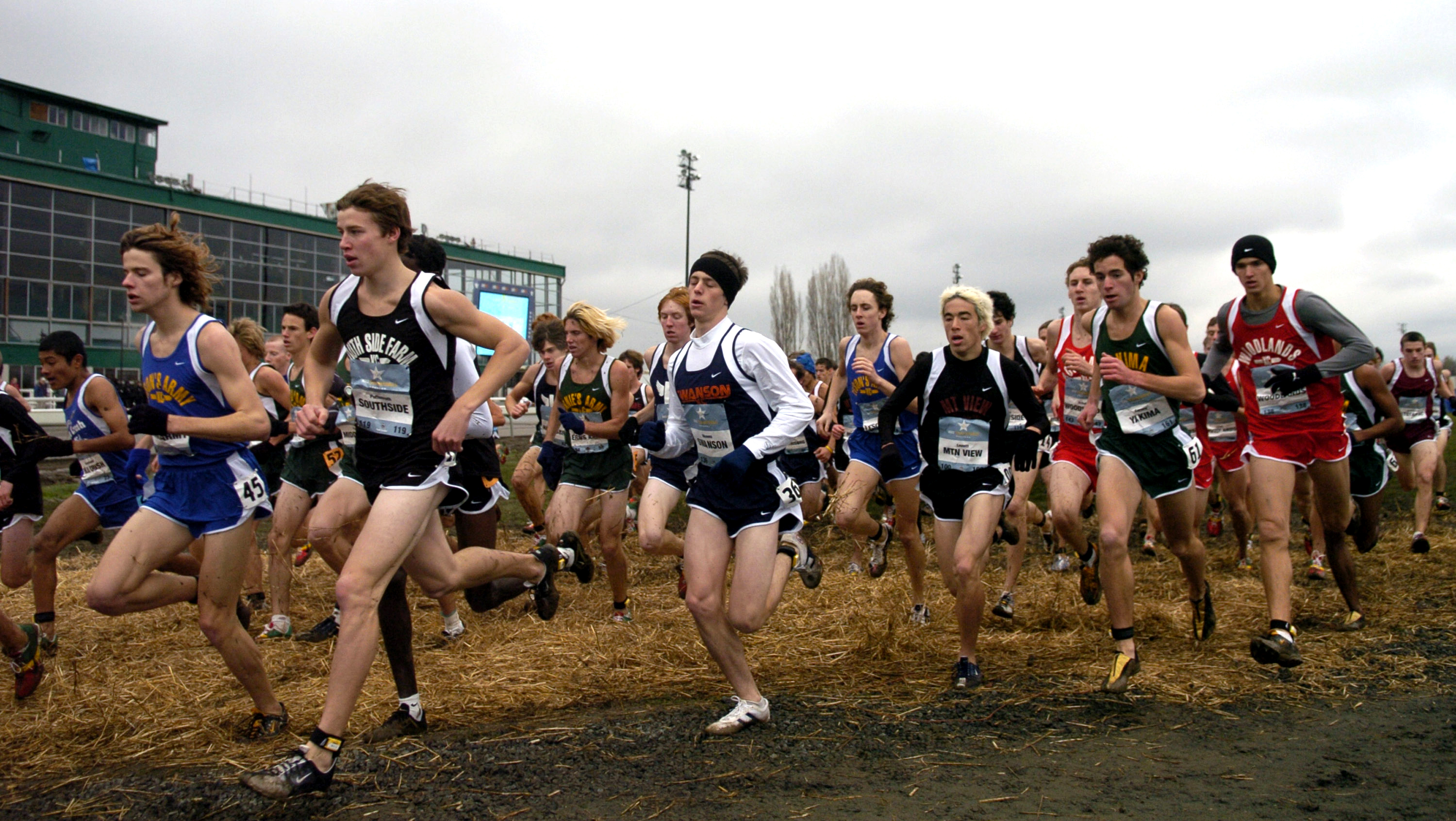 Runners in the boys race of the Nike Team National Cross Country championships pass in front of the Portland Meadows Race Track Grandstand in Portland, Ore. on Saturday, Dec. 4, 2004.