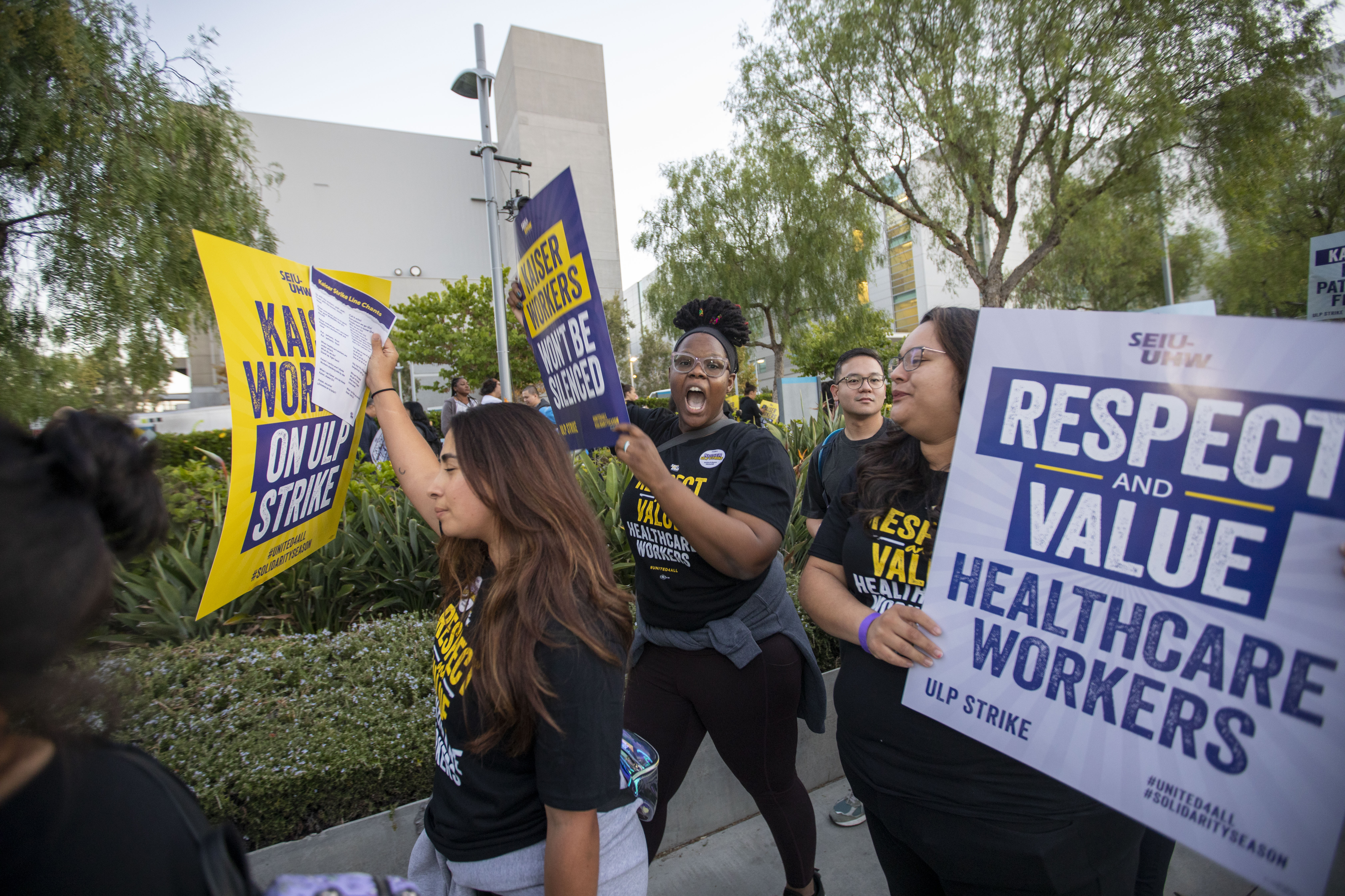 Protesters marching outside a Los Angeles Kaiser facility on October 4 carry signs that read “Respect and value health care workers.”