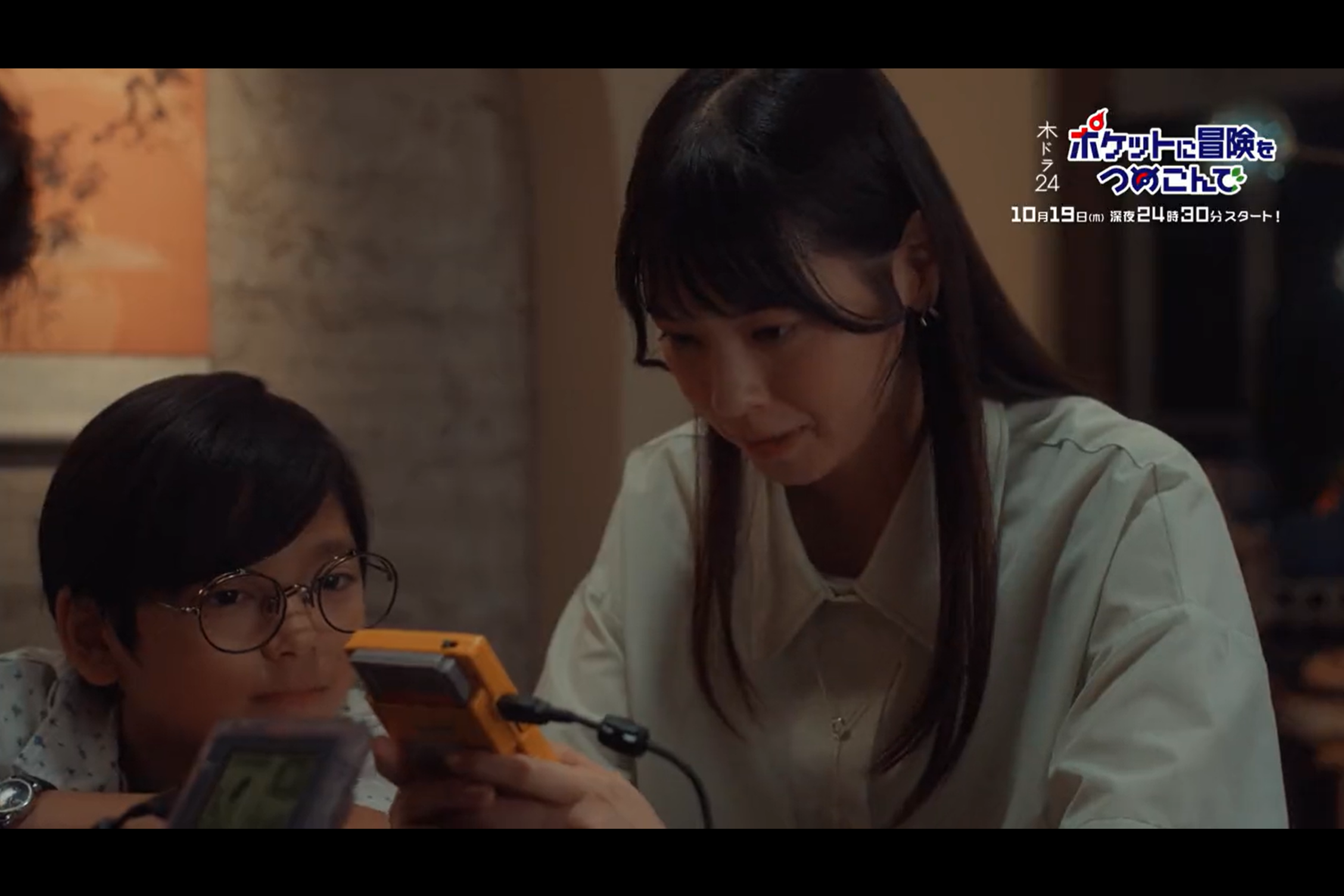 An adult woman and a child playing Game Boys together