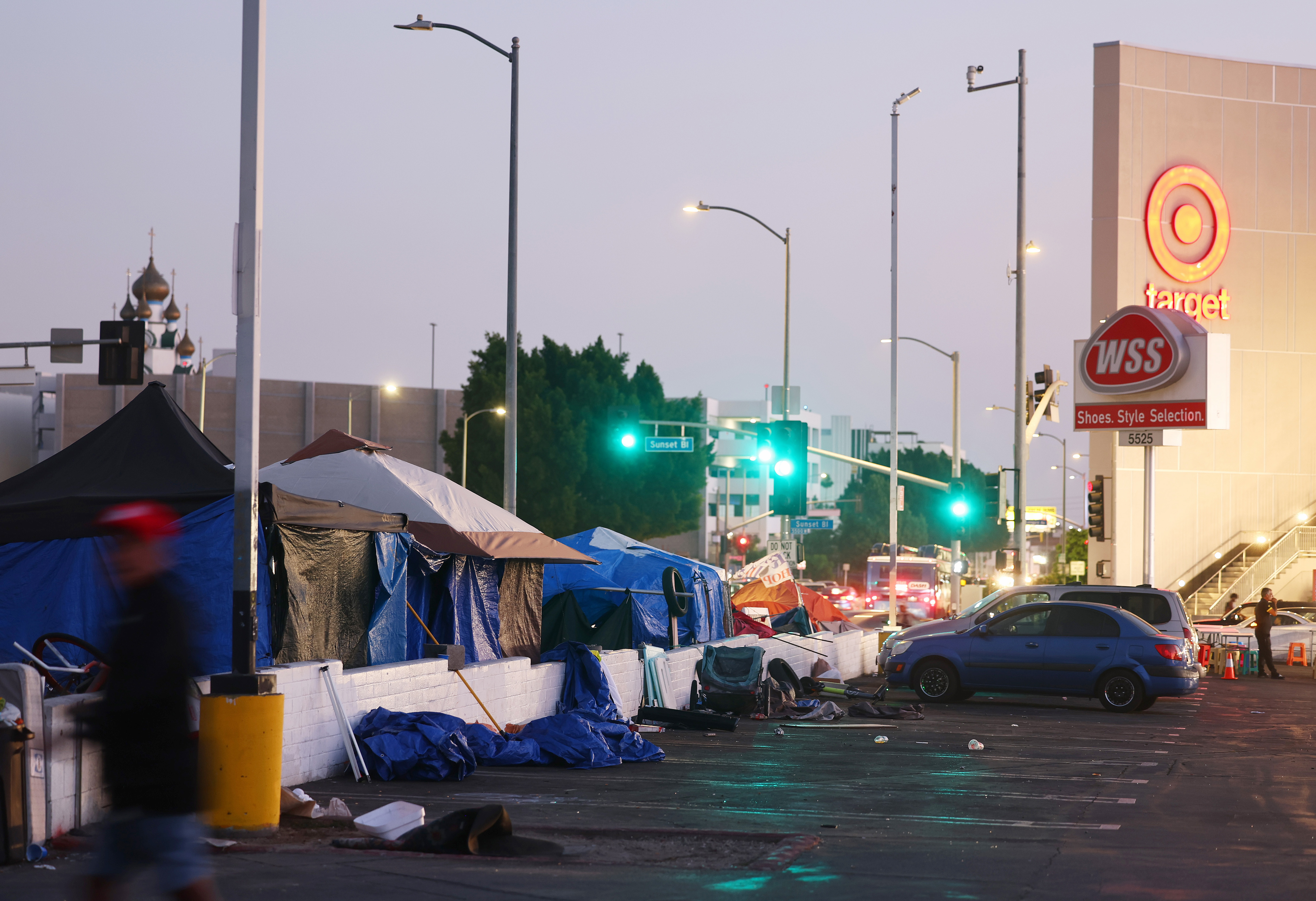 A person walks past a homeless encampment