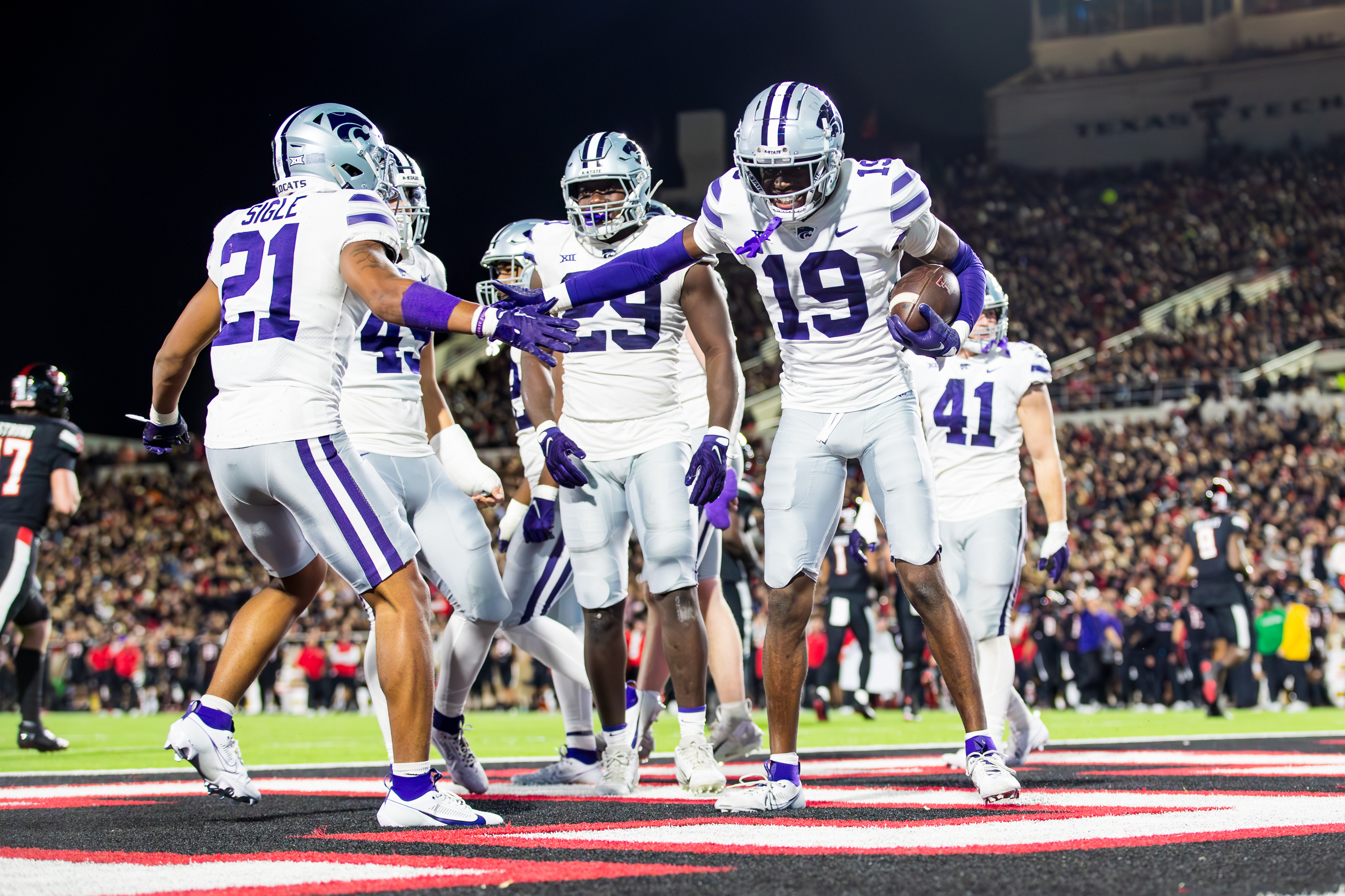 LUBBOCK, TEXAS - OCTOBER 14: VJ Payne #19 of the Kansas State Wildcats high fives Marques Sigle #21 during the second half of the game against the Texas Tech Red Raiders at Jones AT&amp;T Stadium on October 14, 2023 in Lubbock, Texas.