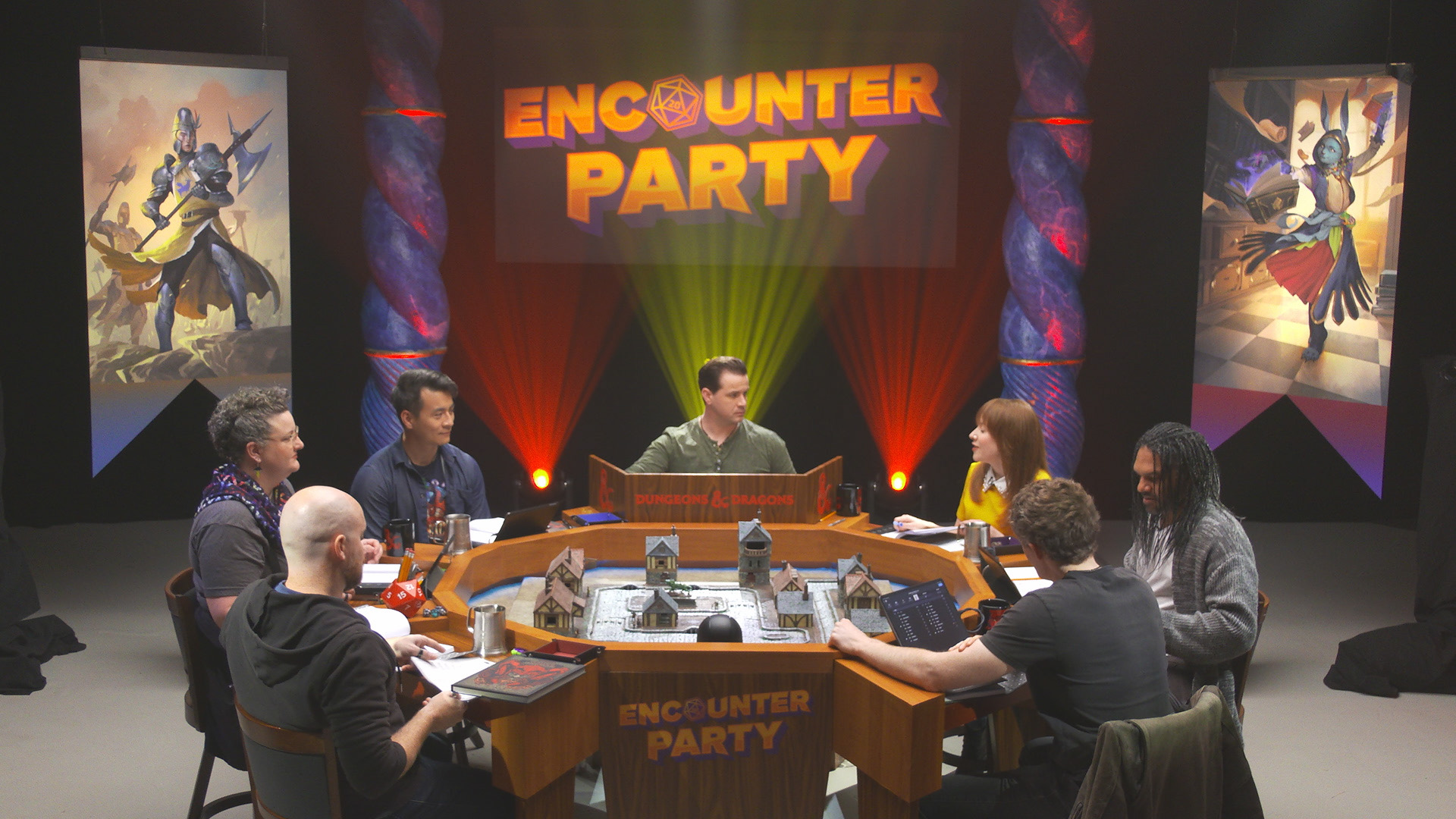 The cast of Encounter Party sits around the table, ready to play. 