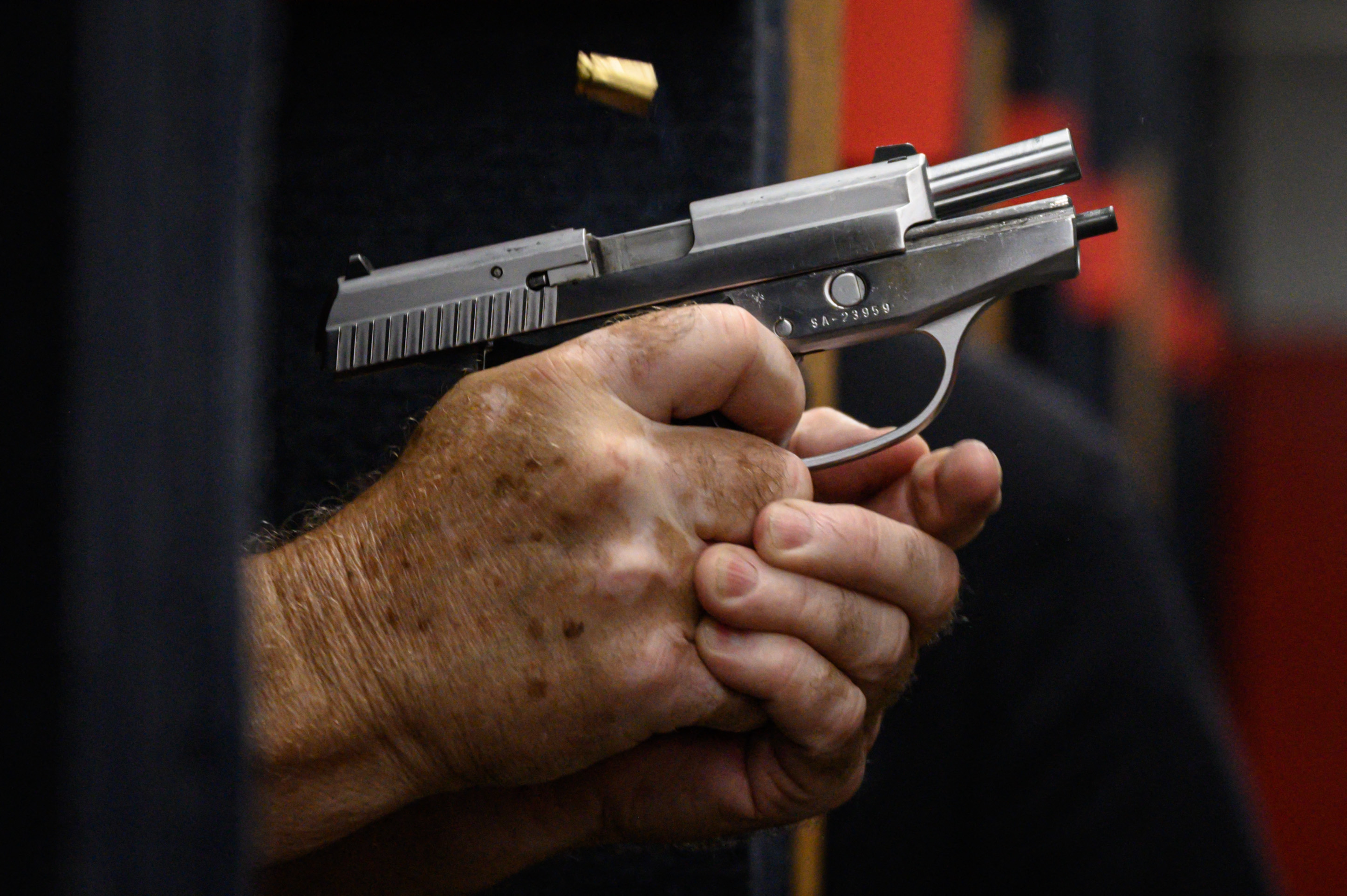 A handgun held in two hands and pointed away from the holder.