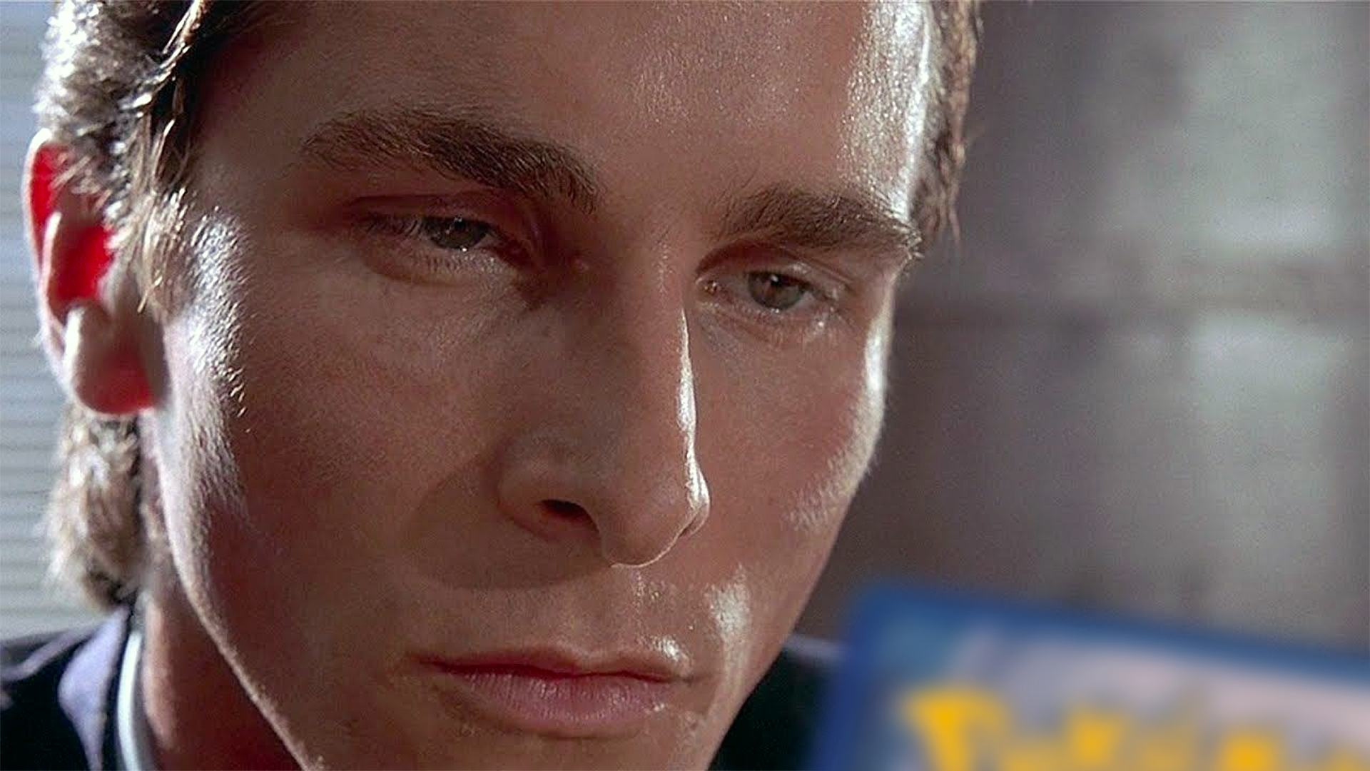 A still of Patrick Bateman contemplating a business card from the movie American Psycho, with a Pokémon card swapped in for Paul Allen’s business card