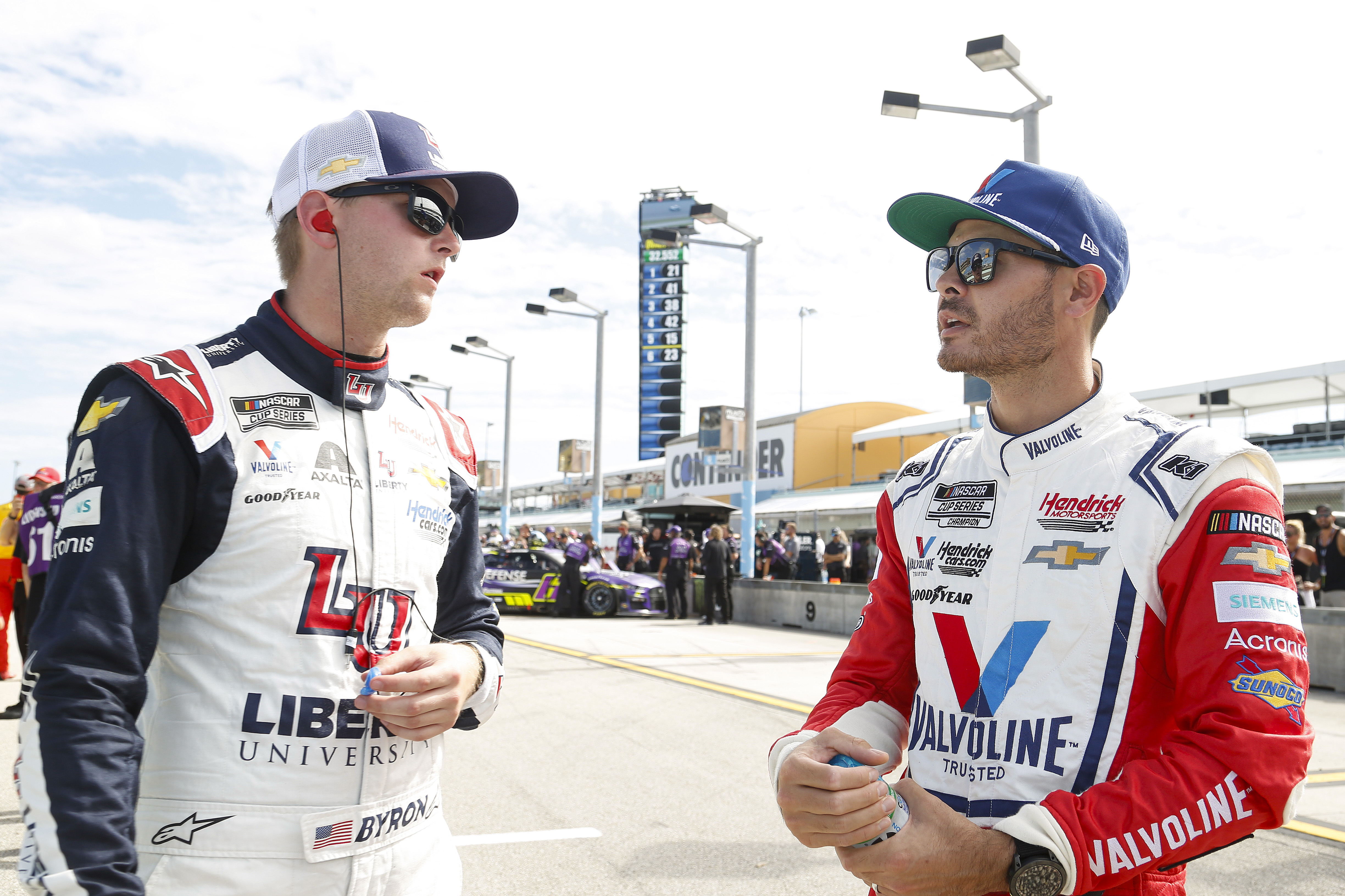 William Byron, driver of the #24 Liberty University Chevrolet,(L) and Kyle Larson, driver of the #5 Valvoline Chevrolet, talk on the grid during qualifying for the NASCAR Cup Series Dixie Vodka 400 at Homestead-Miami Speedway on October 22, 2022 in Homestead, Florida.