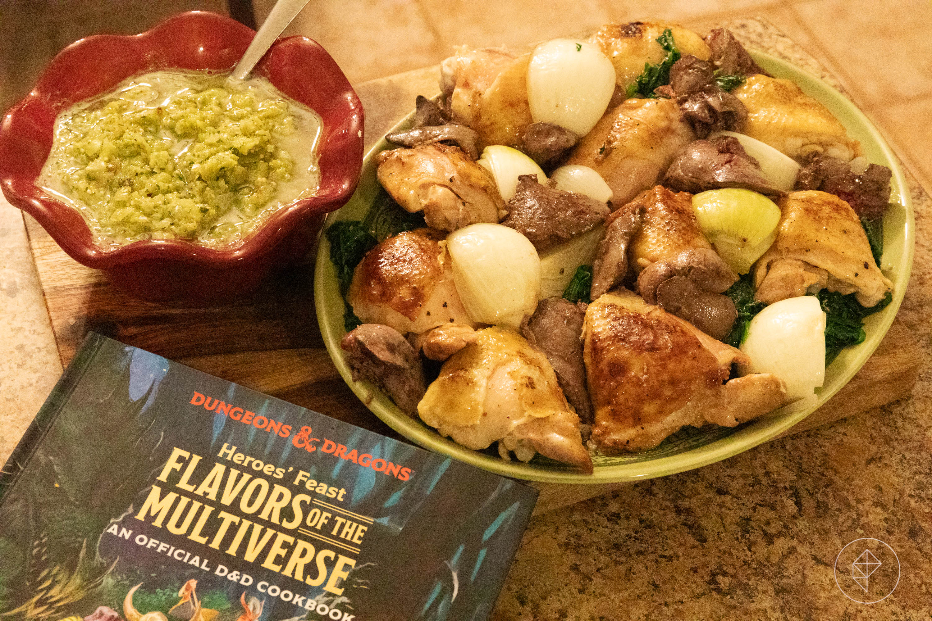 Bits of chicken and roast onion sitting on a green dinner plate, next to a tomatillo salsa in a red bowl.