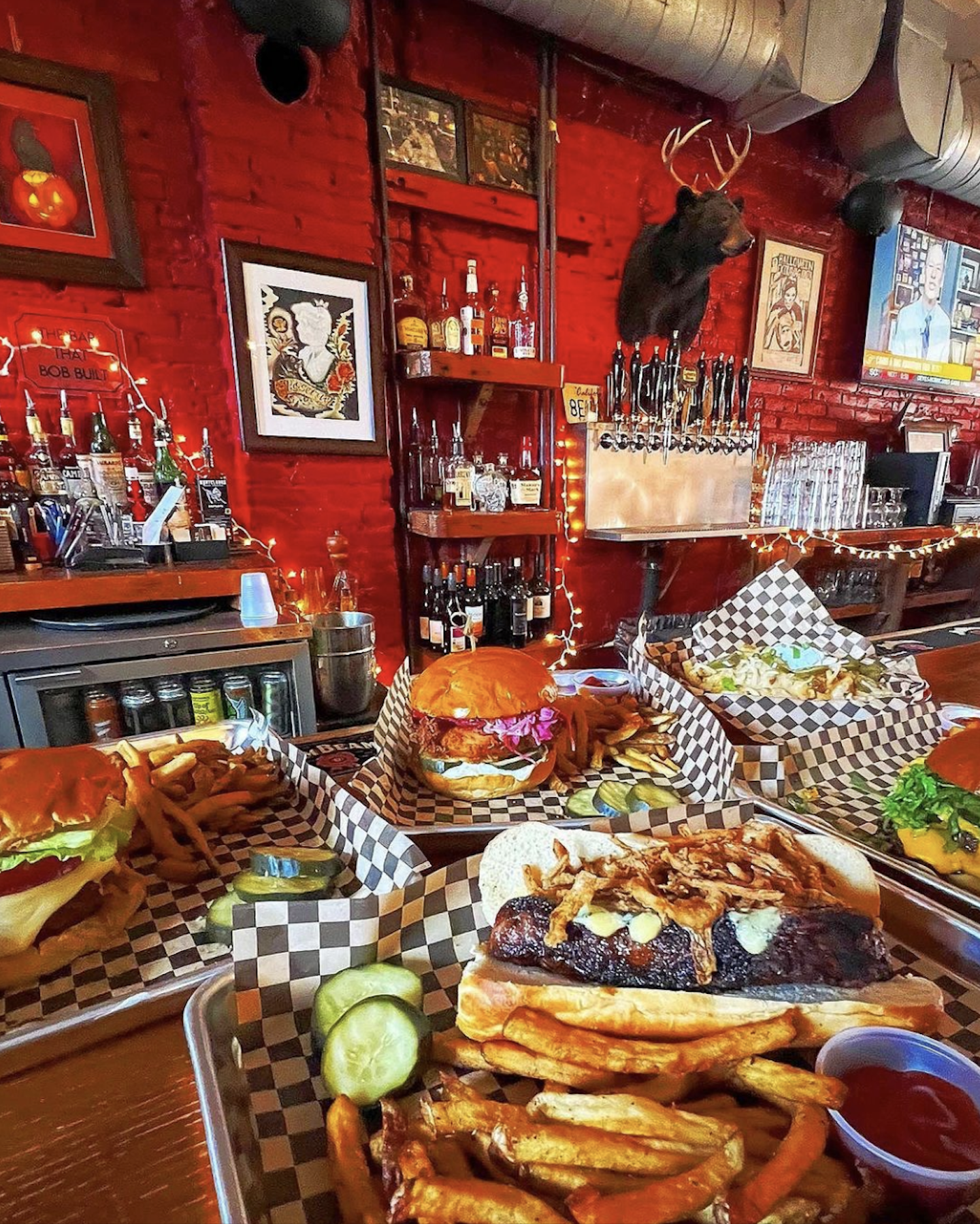 A lively bar featuring a counter that includes burgers, fries, and sandwiches. 