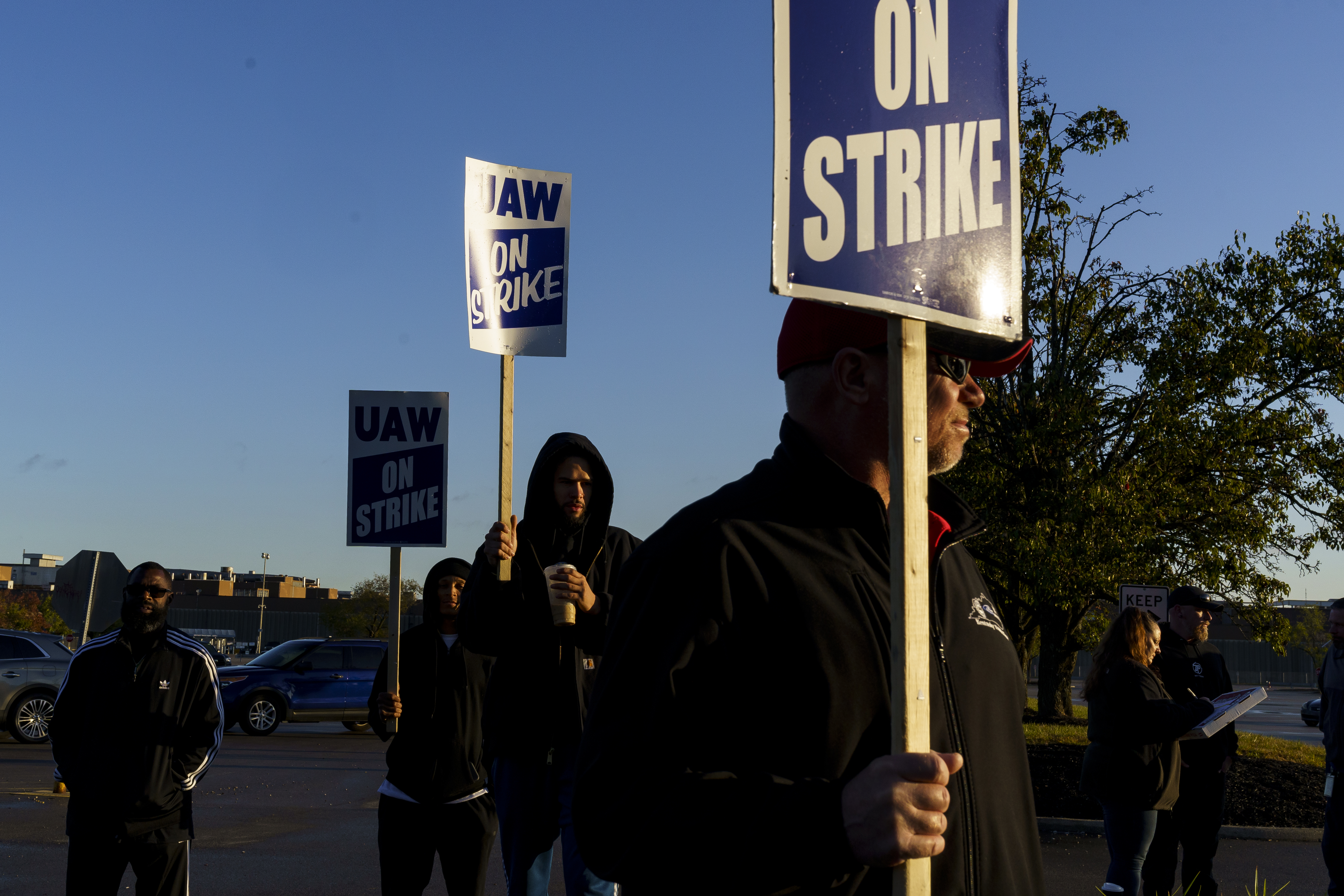 Workers walking with signs saying “on strike.”