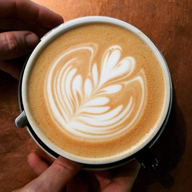 A latte coffee drink with cream swirls.