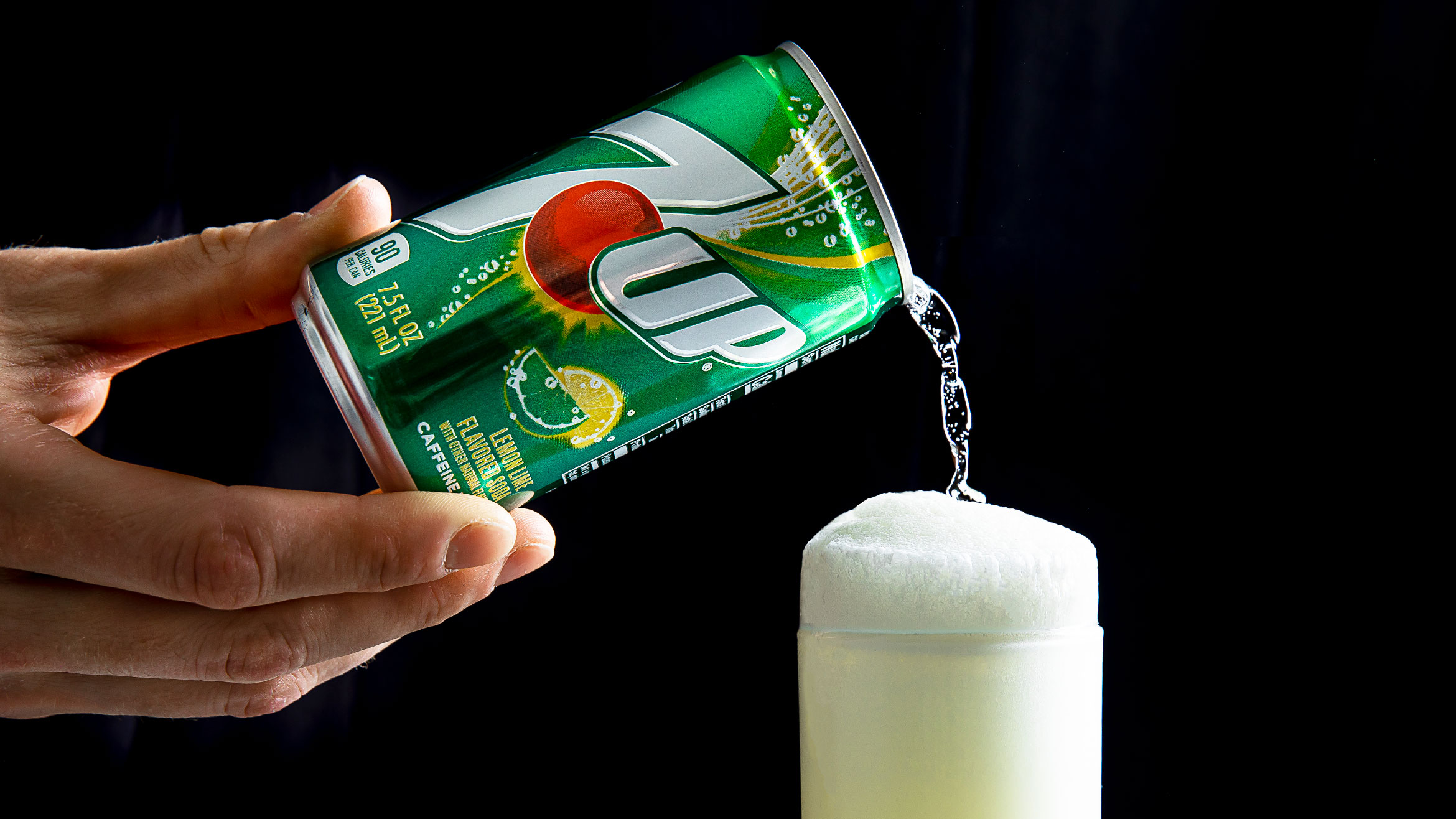 A can of 7Up being poured into a glass