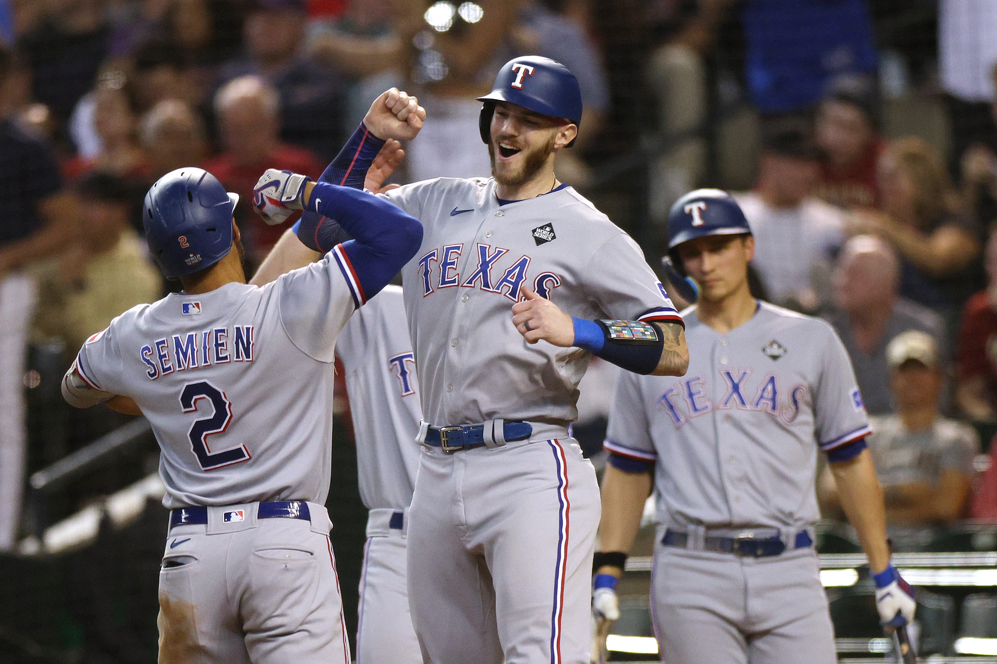 Marcus Semien and Jonah Heim of the Texas Rangers celebrate after Semien hit a home run in the third inning against the Arizona Diamondbacks during Game Four of the World Series at Chase Field on October 31, 2023 in Phoenix, Arizona.