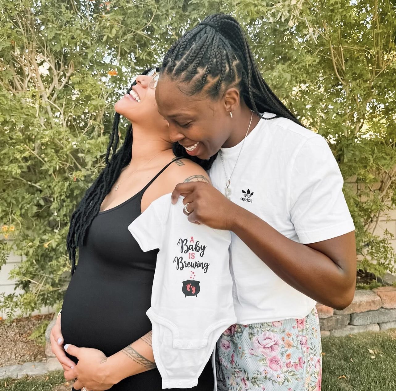 Basketball player poses with her pregnant wife.
