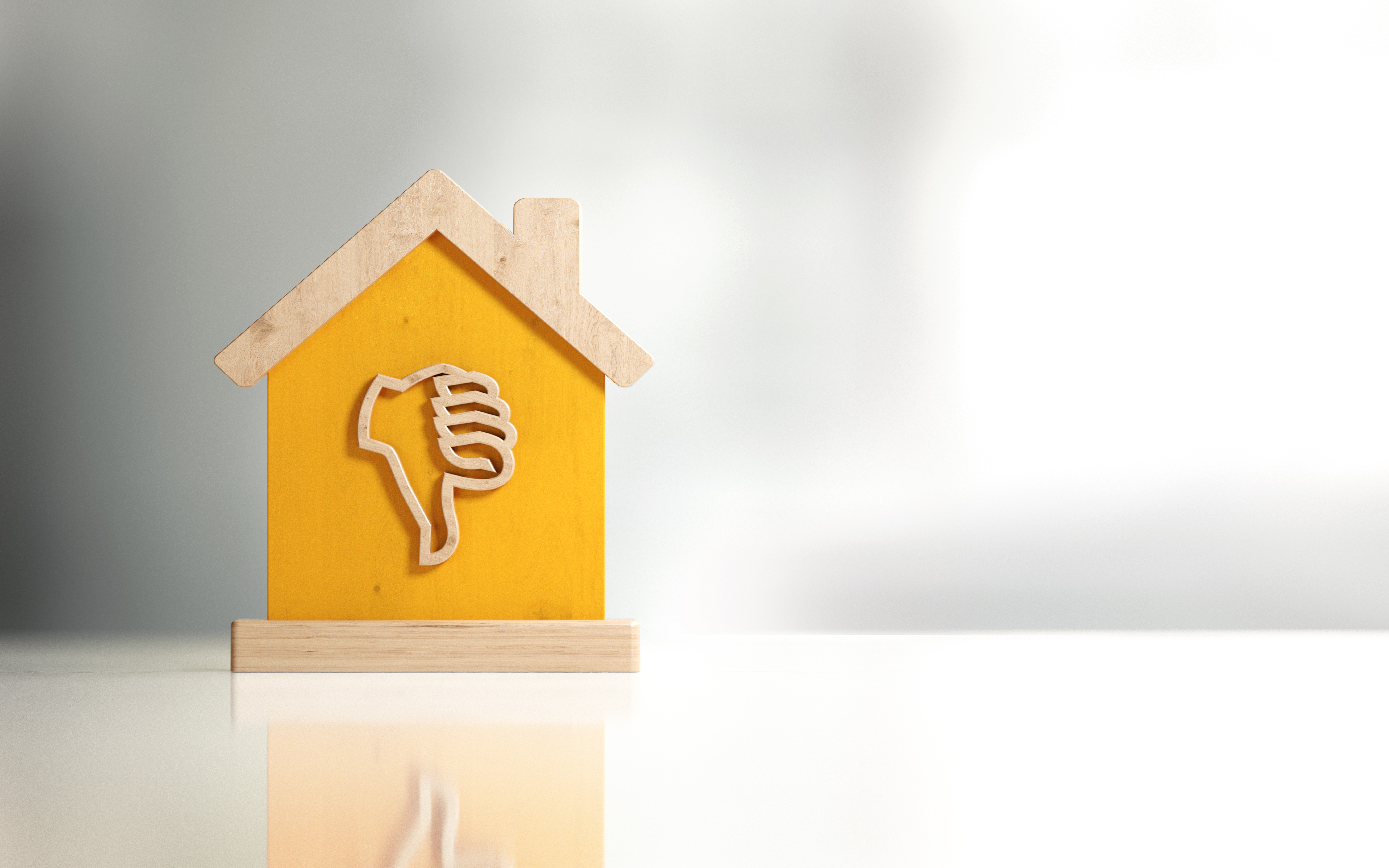 A wooden toy house with a thumbs-down symbol on it.